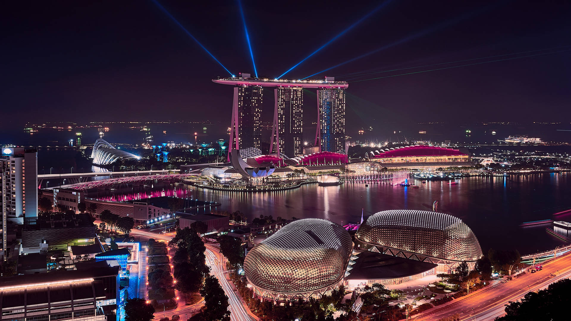 新加坡夜晚的城市景觀，有發光的建築物和水面上的激光束。