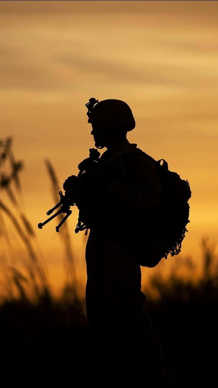 日落時分草地上持步槍的士兵剪影