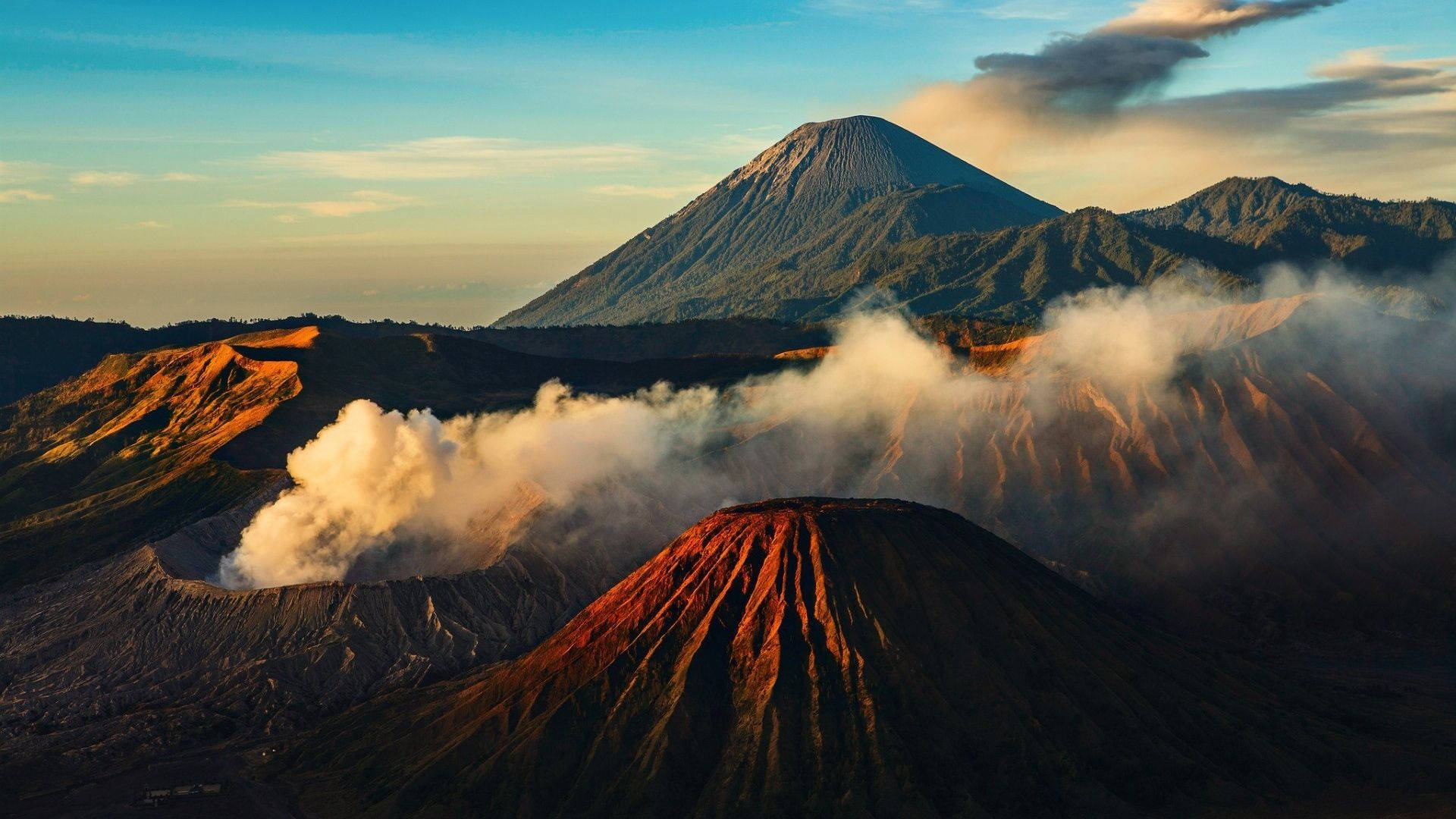 日出時蒸氣升起的火山山脈