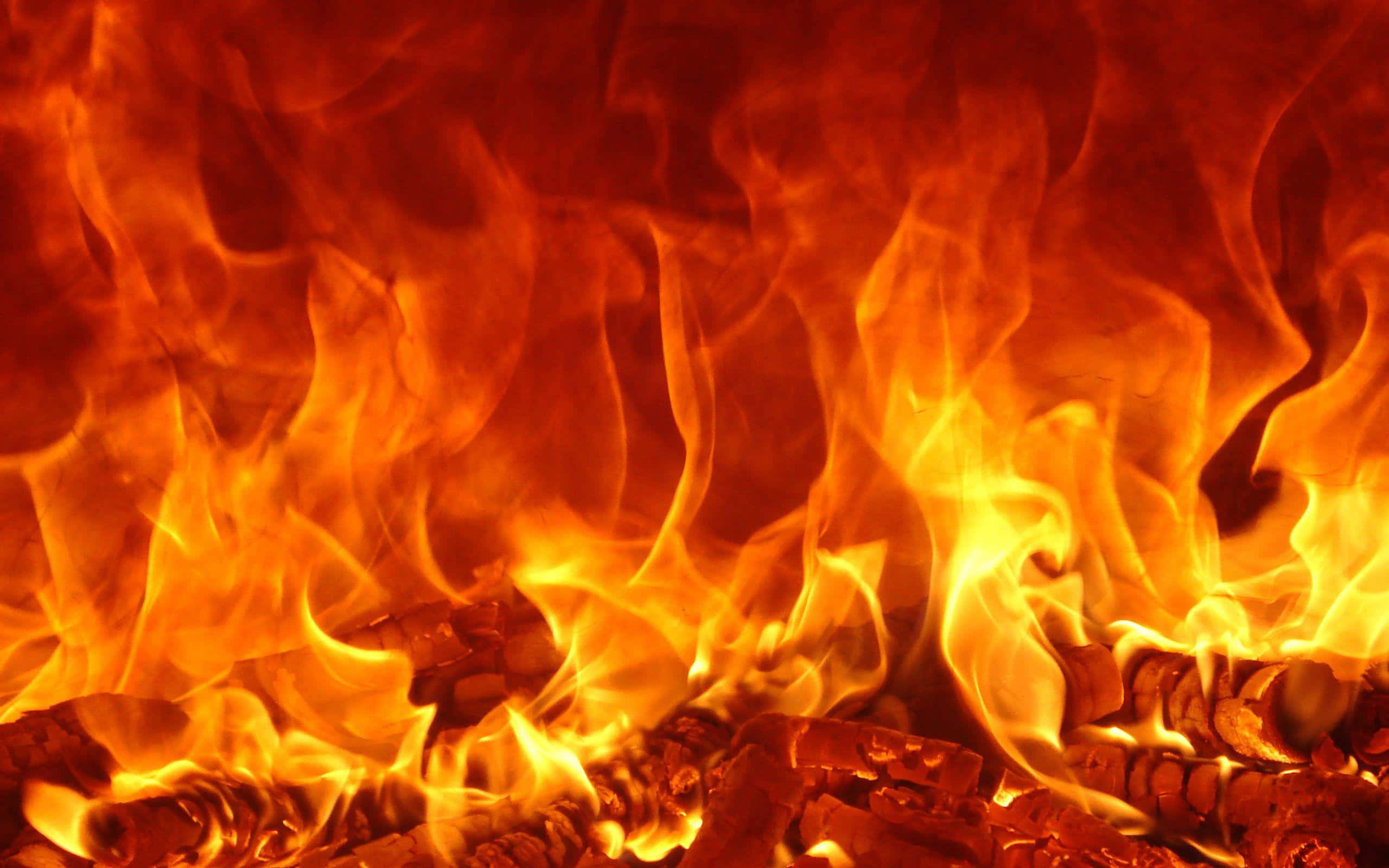 Flame 桌布 壁紙 — 火焰中，熾熱的橙色和黃色火焰在發光的餘燼上舞動的鮮明特寫。