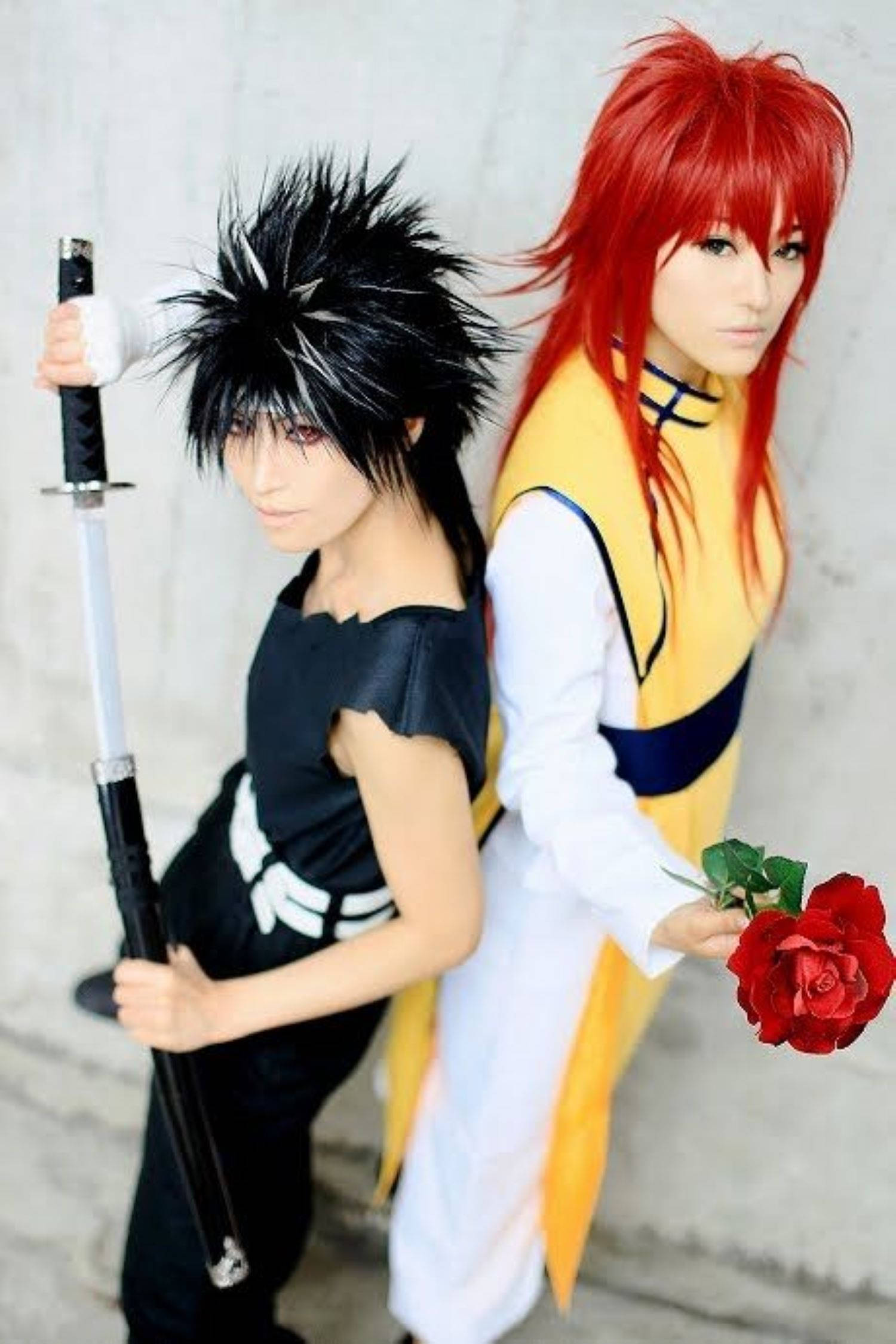 火野紅葉與飛影Cosplay 壁紙 — 兩位動漫角色扮演者，一位黑色刺蝟頭手持劍，另一位紅髮手持紅玫瑰，背景為素色牆壁。