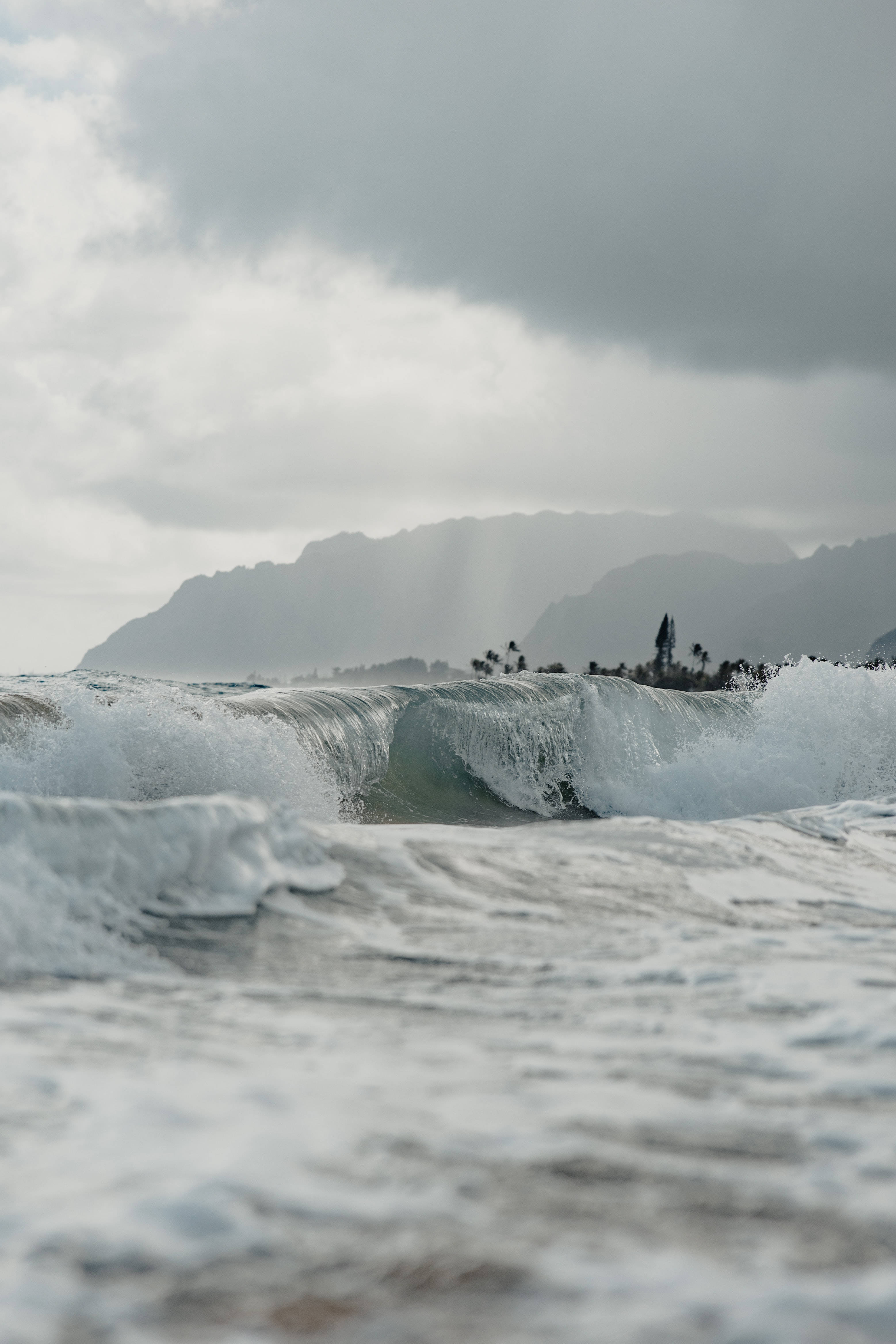 灰濛海浪暴風雨 壁紙 — 強大的海浪在厚重的陰天下拍打著遙遠的山區海岸線。