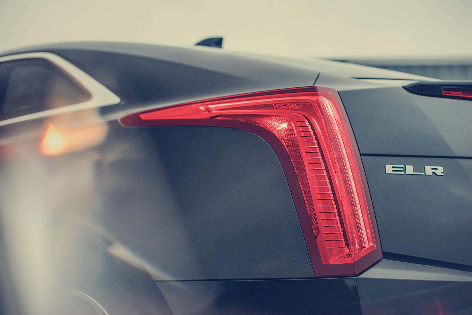 Cadillac Elr 桌布 壁紙 — 灰色Cadillac ELR的紅色發光尾燈特寫，具有銳利的棱角設計和金屬徽章。