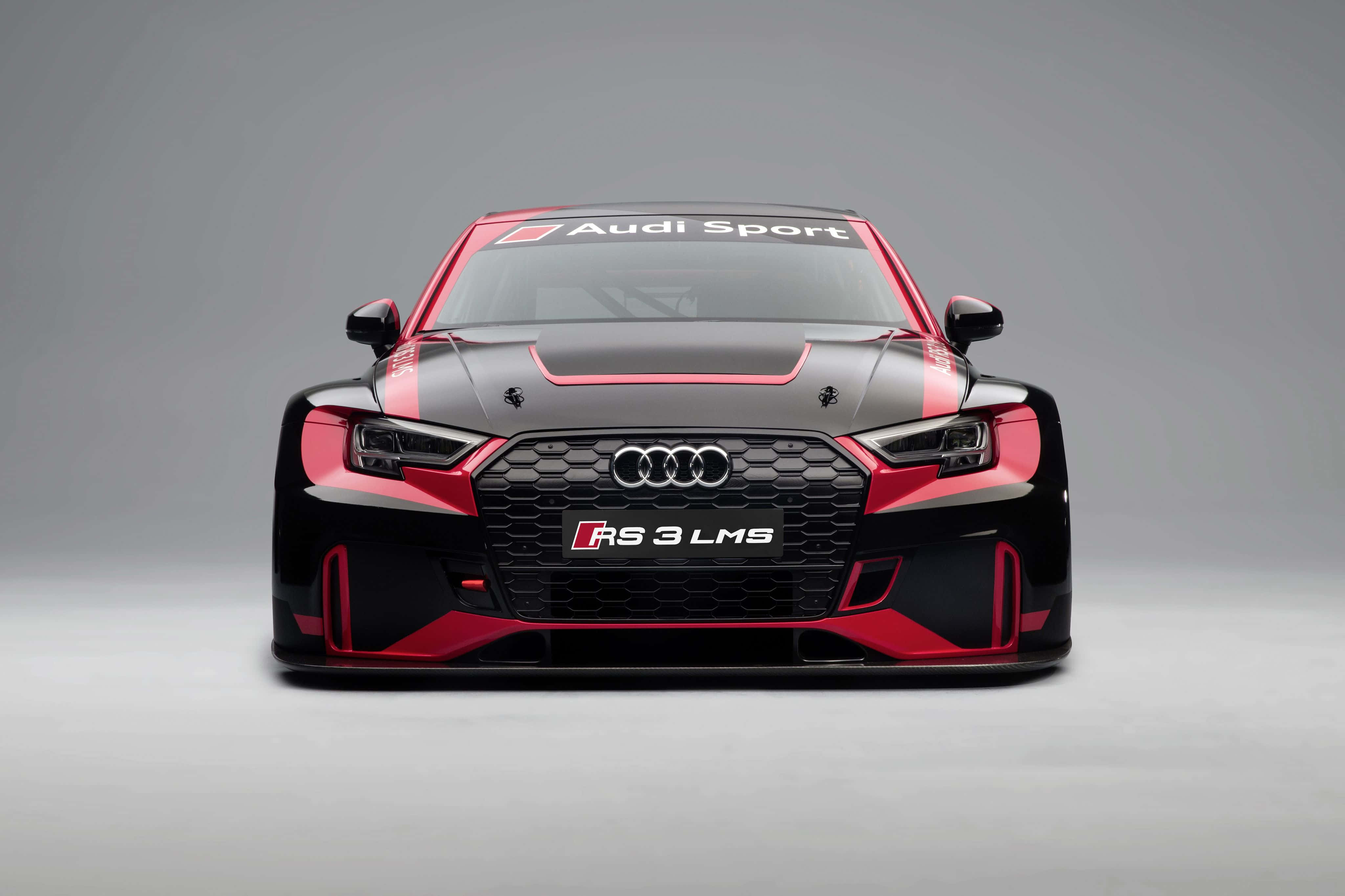 Audi Rs3 桌布 壁紙 — 灰色工作室背景前，一輛黑色和紅色的Audi RS 3 LMS賽車正面視圖，擋風玻璃上有'Audi Sport'貼紙。