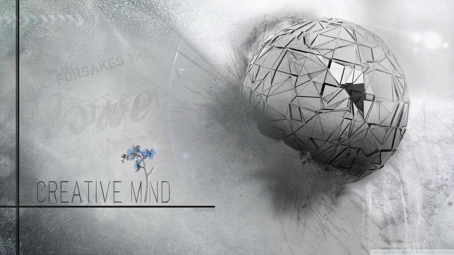 一個破碎的幾何球體漂浮在一朵小藍花和文字 creative mind 旁邊。