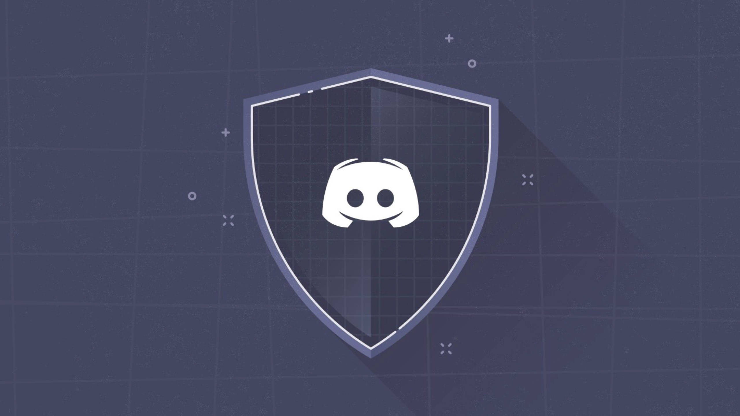 灰色盾牌風格Discord標誌 壁紙 — 一個白色 Discord 標誌置中於盾牌內，背景為深藍色網格，帶有微妙的幾何裝飾。