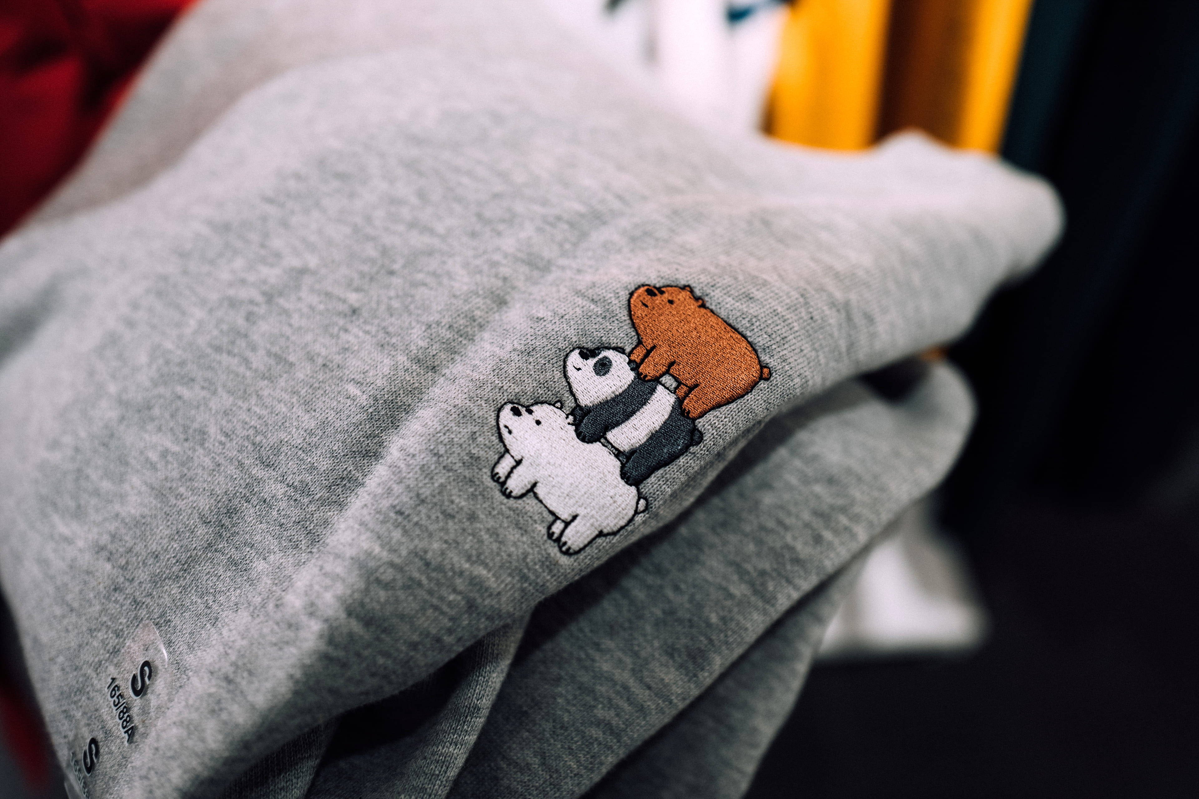We Bare Bears 桌布 壁紙 — 灰色衛衣近鏡，上面有色彩繽紛嘅刺繡圖案，係三隻卡通熊疊埋一齊。