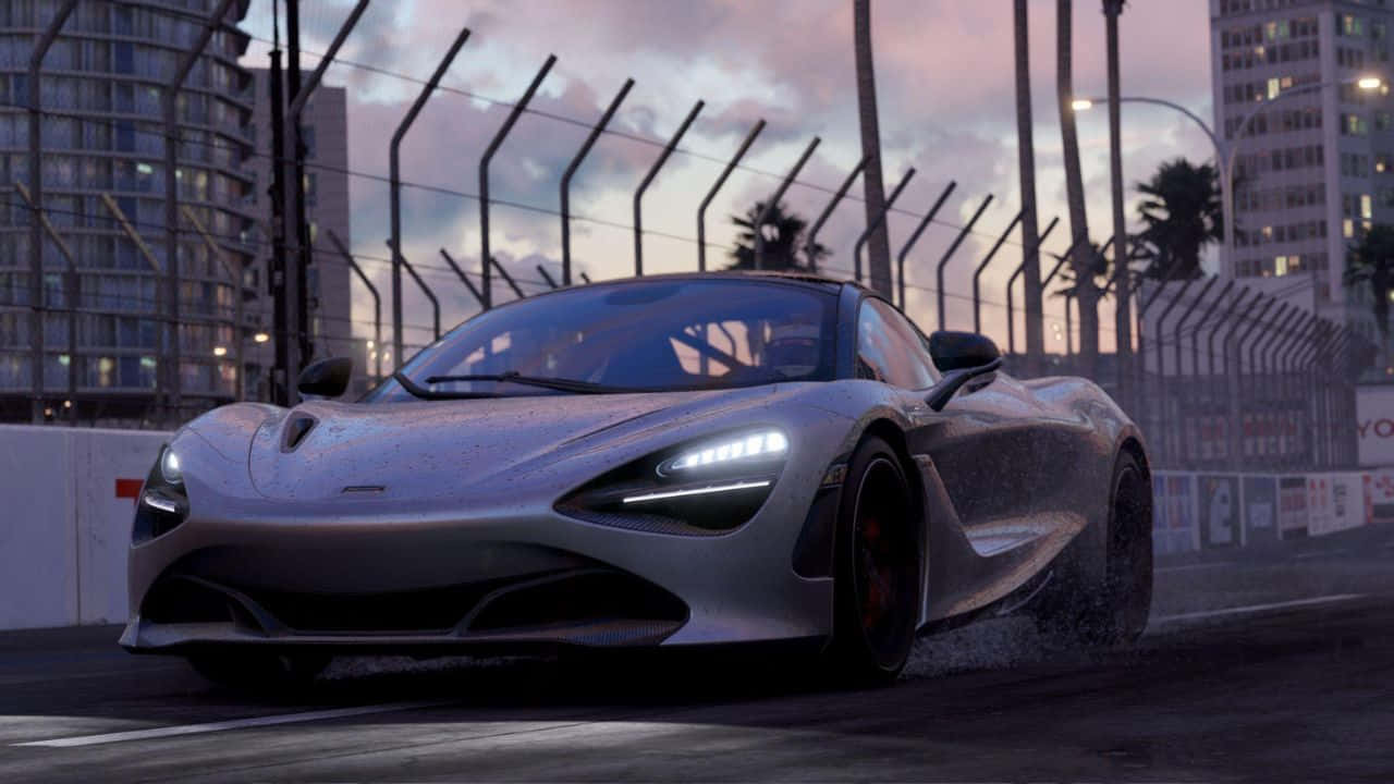 灰色麥拉倫 720s 720p 項目賽車背景 壁紙 — 一輛銀色McLaren跑車在黃昏時分於城市賽道上飄移，背景有棕櫚樹和摩天大樓。