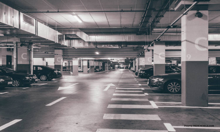空的地下停車場，有停泊的汽車和地板上的白色方向箭頭。