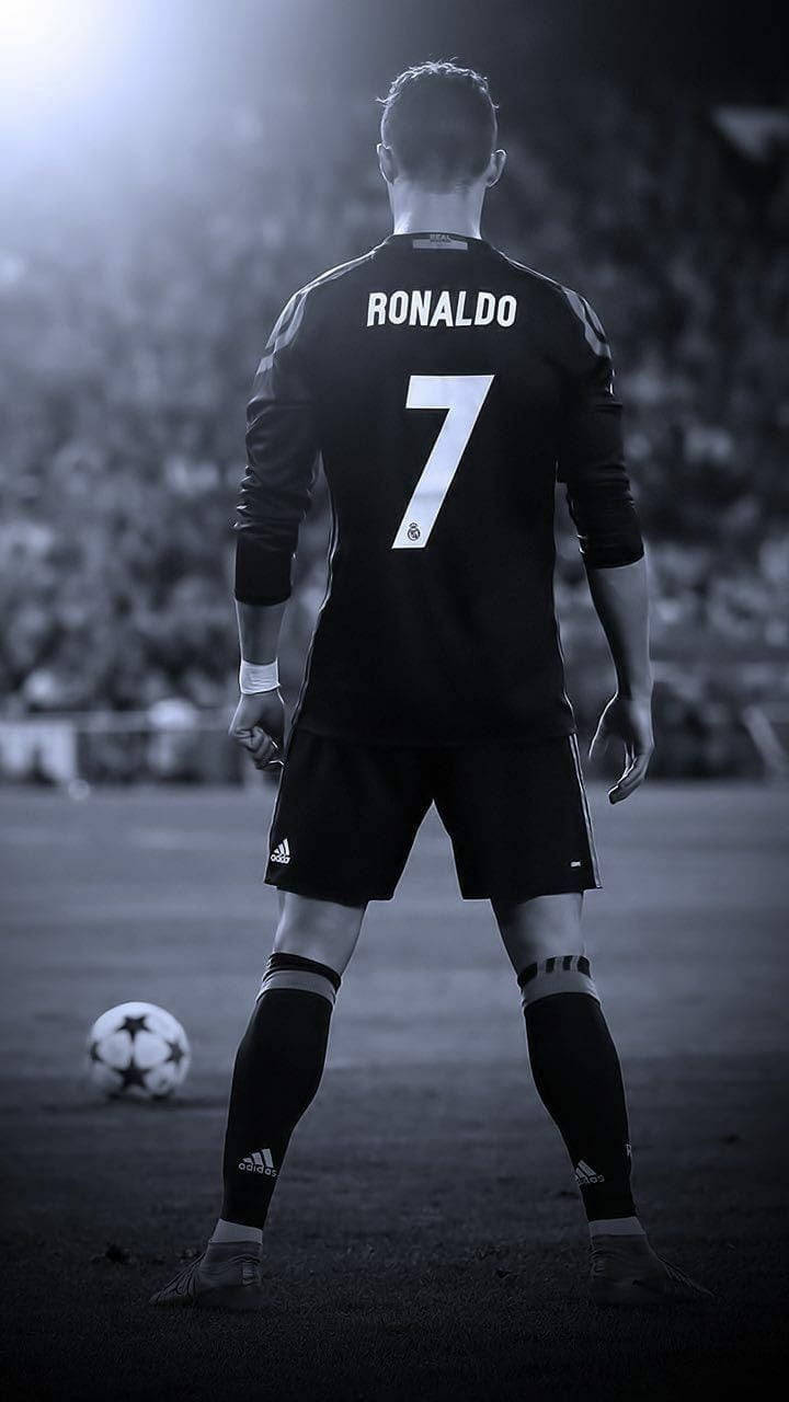 Cristiano Ronaldo身穿黑色7號球衣，站在足球場上。