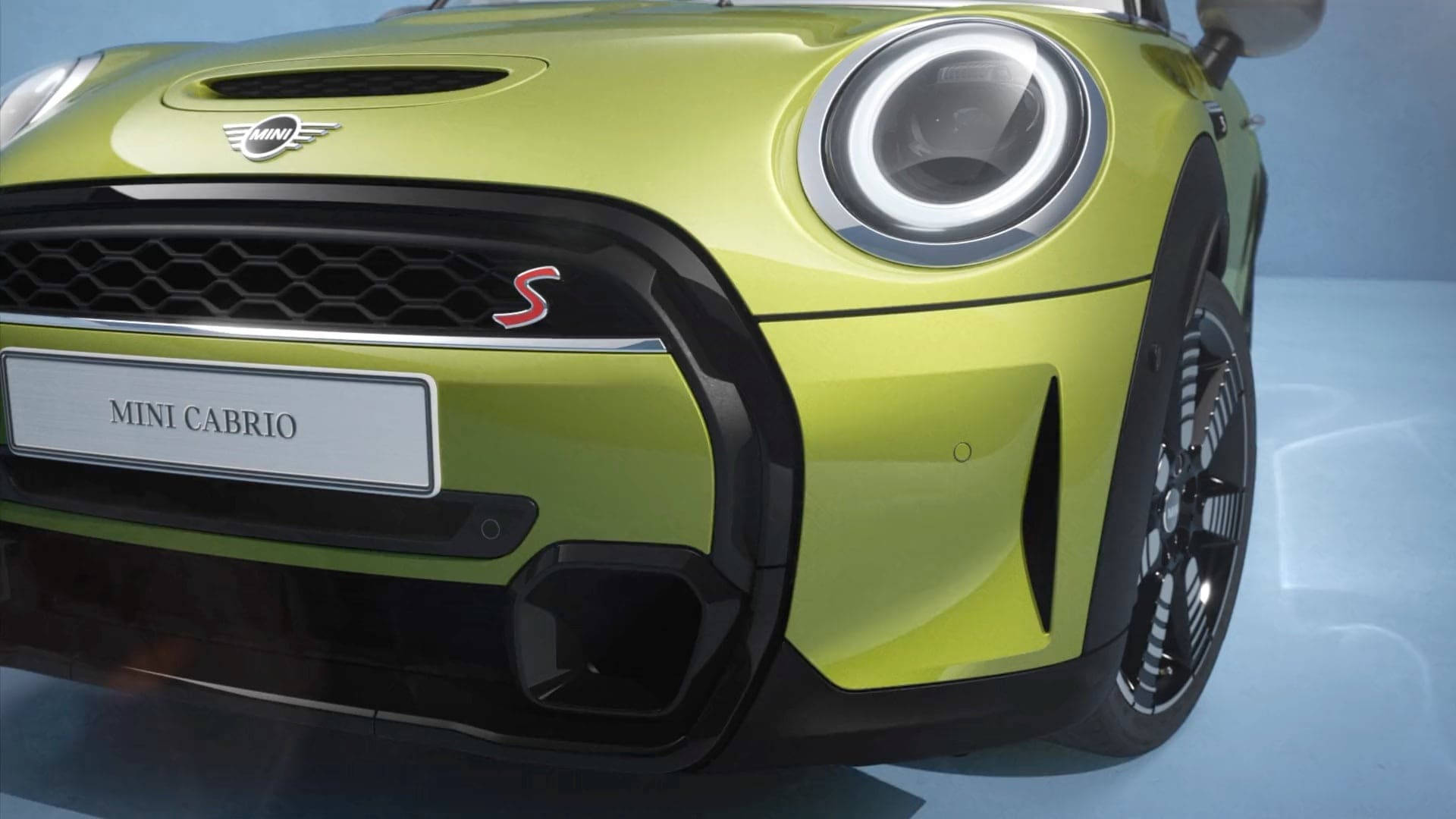 炫目霓虹綠 Mini Cooper 與發光頭燈 壁紙 — 充滿活力的青檸綠色 MINI CABRIO S 正面視圖，帶有發光的圓形頭燈和黑色飾邊，背景為攝影棚。
