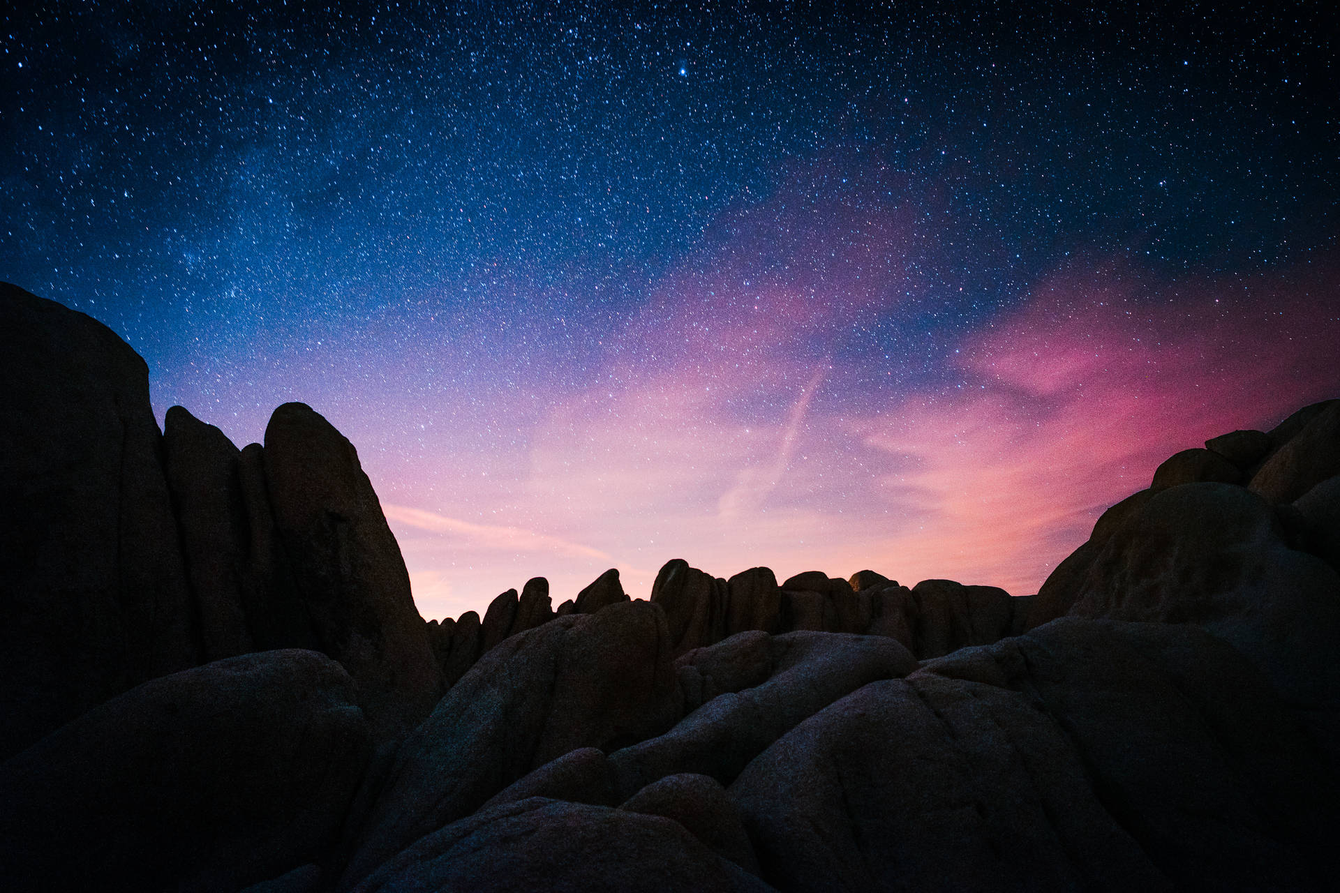 在充滿活力的星空暮色下，深色岩層呈現紫色和藍色調。 — 太空 壁紙