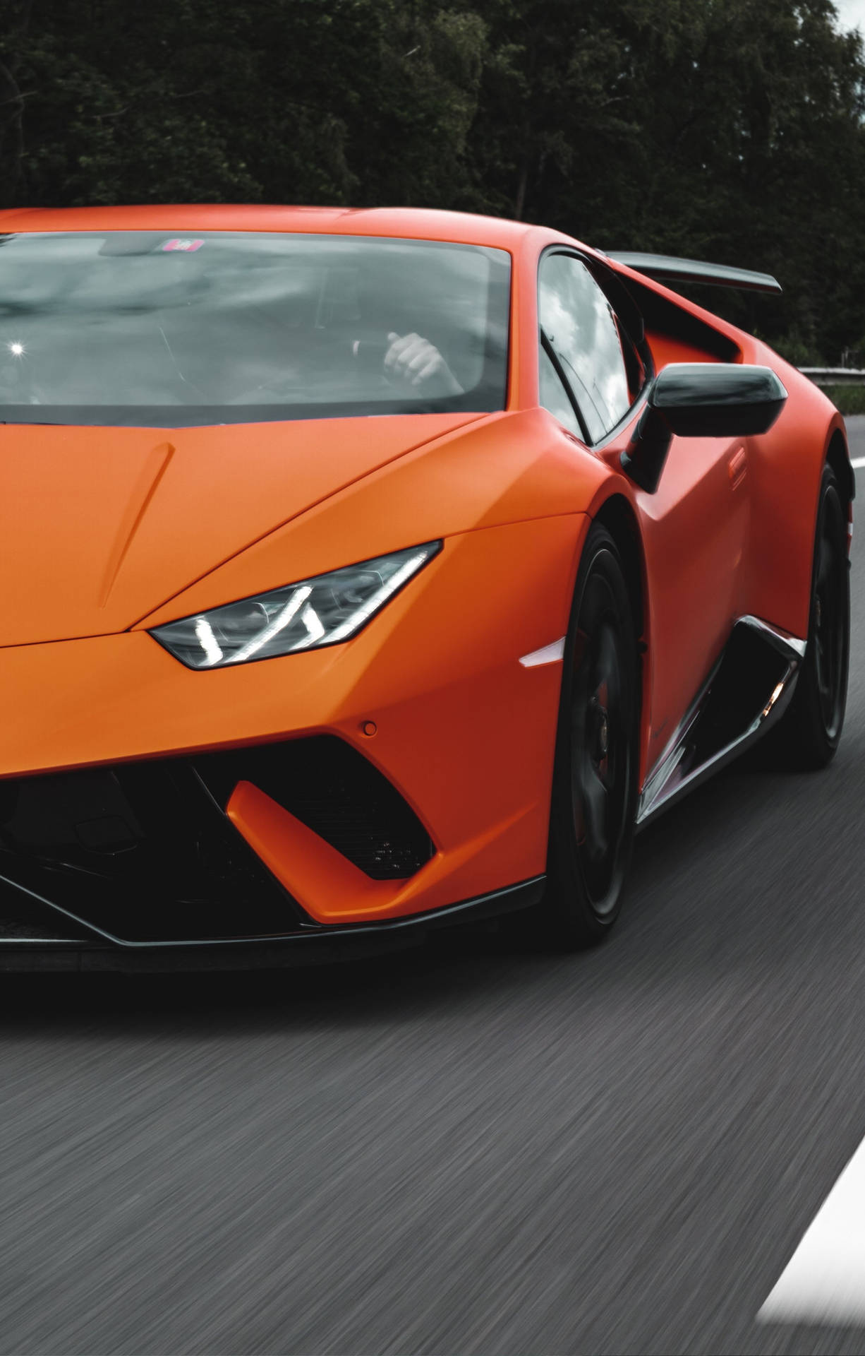 橙色林寶堅尼 Huracán 在賽道上奔馳，帶有動態模糊效果。