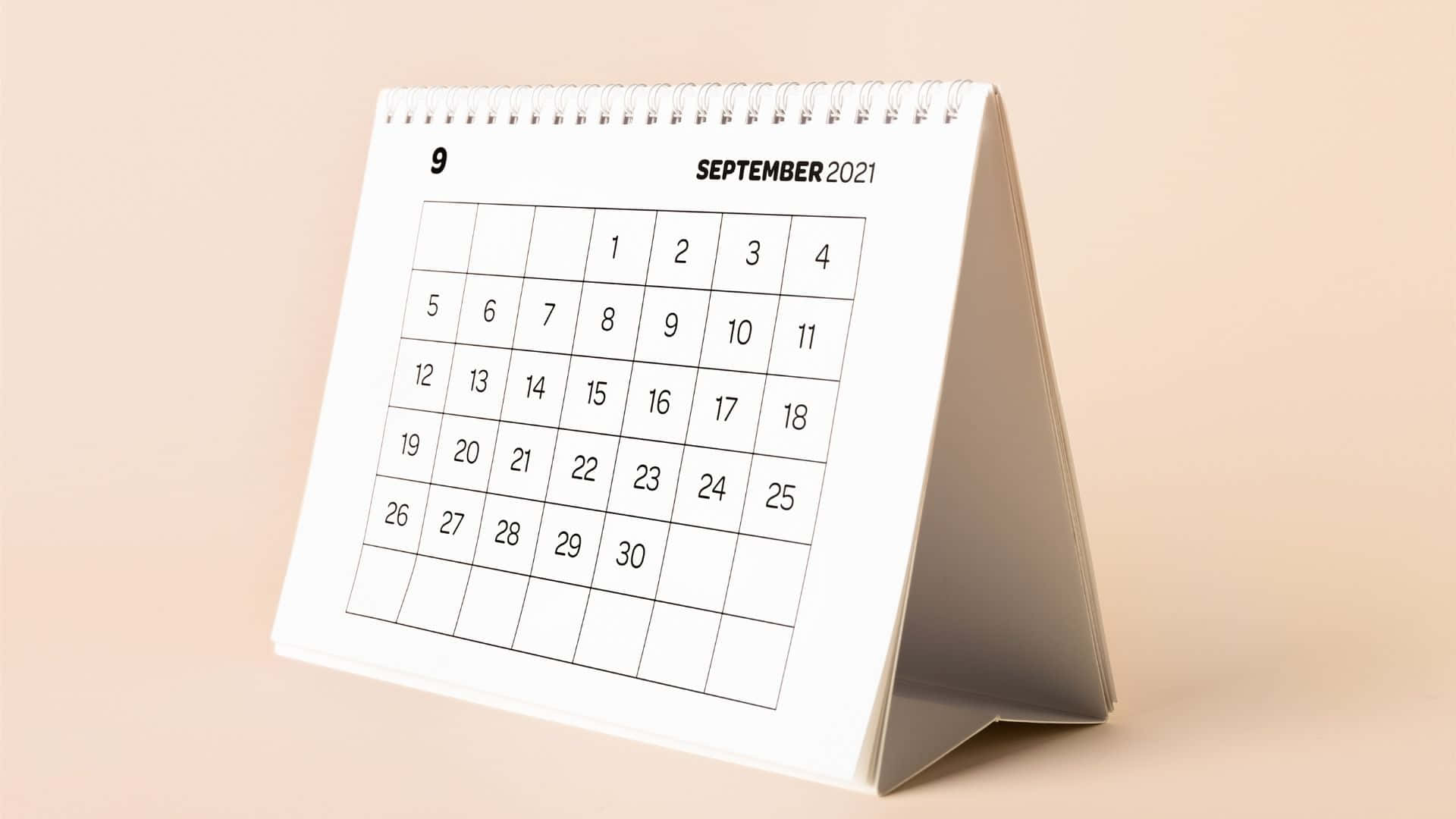 一個白色座枱日曆，在米色背景上顯示2021年9月。