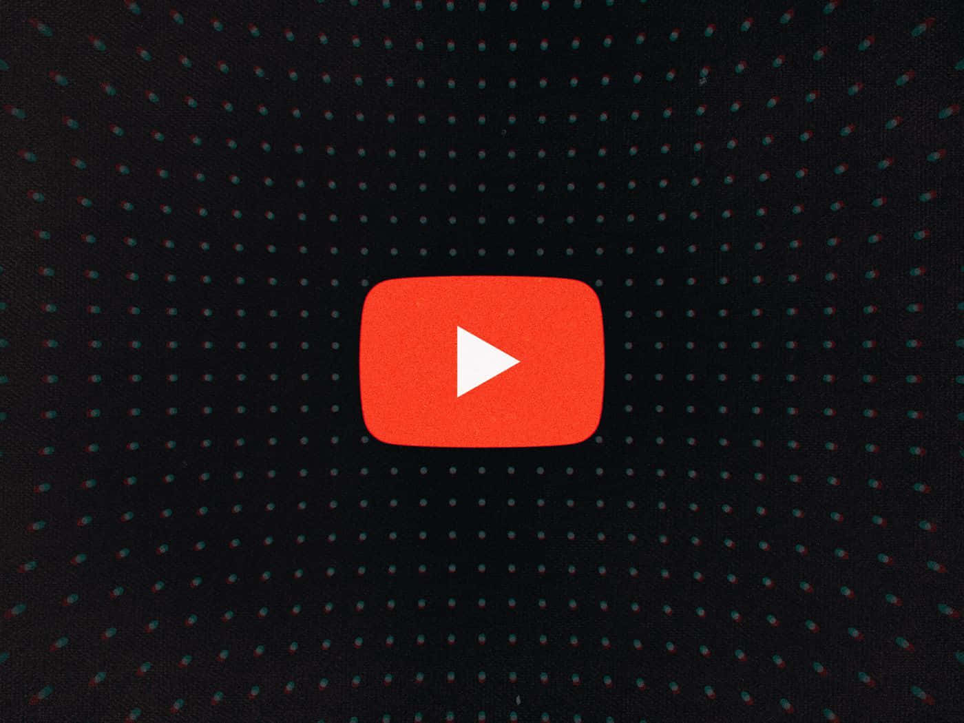 深色布料上帶有彩色圓點的紅色YouTube播放按鈕。