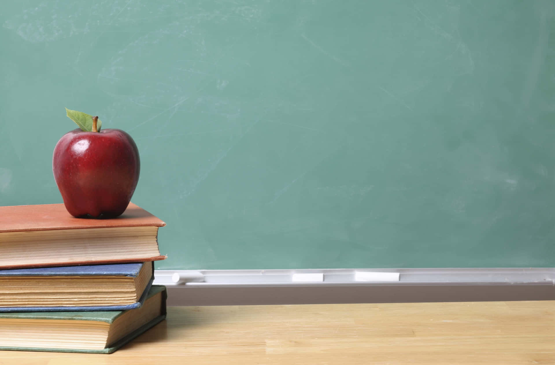 黑板前的書上的紅蘋果