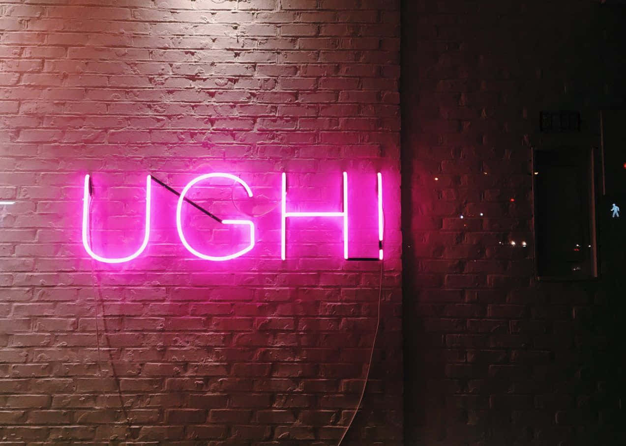 夜晚磚牆上寫著「UGH」的粉紅色霓虹燈牌。