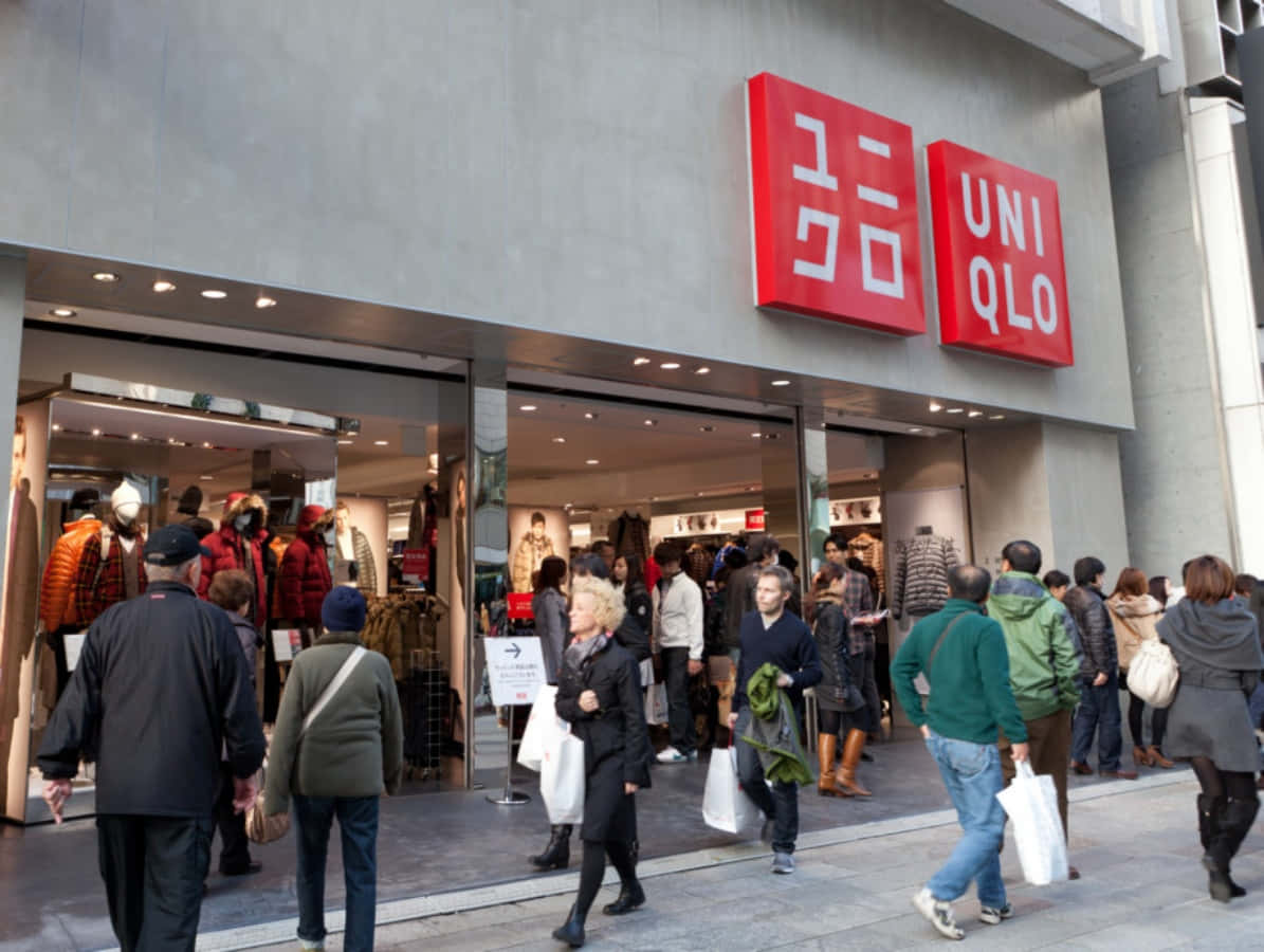 繁忙城市街道上 Uniqlo 服裝店外的購物者。