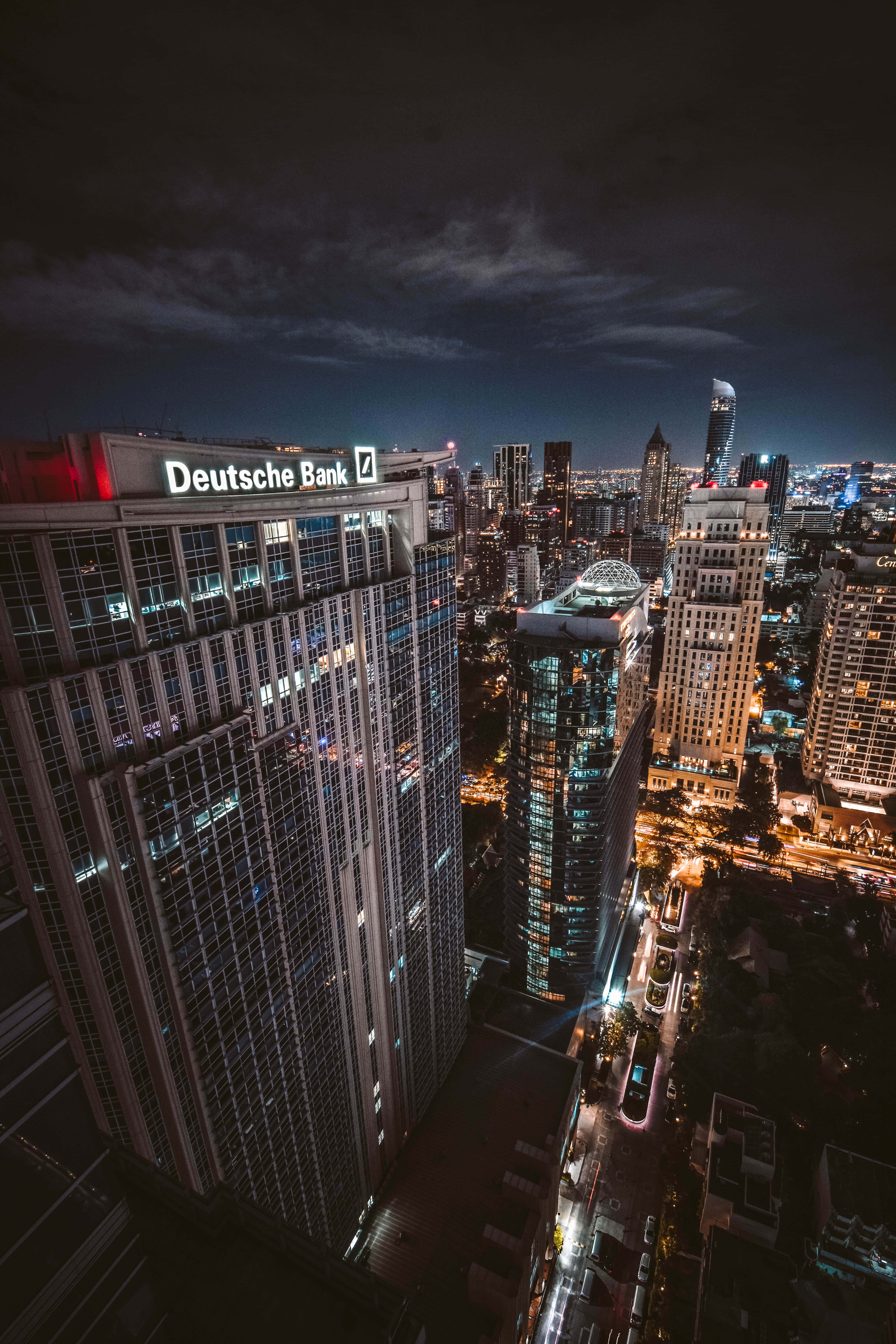 為你的財務未來把關 壁紙 — 在黑暗天空下，密集城市景觀的空中夜景，摩天大樓和街道燈火通明。