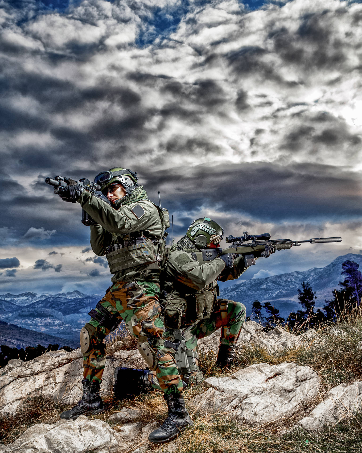 兩名身穿迷彩裝備的武裝士兵在山脊上瞄準步槍。