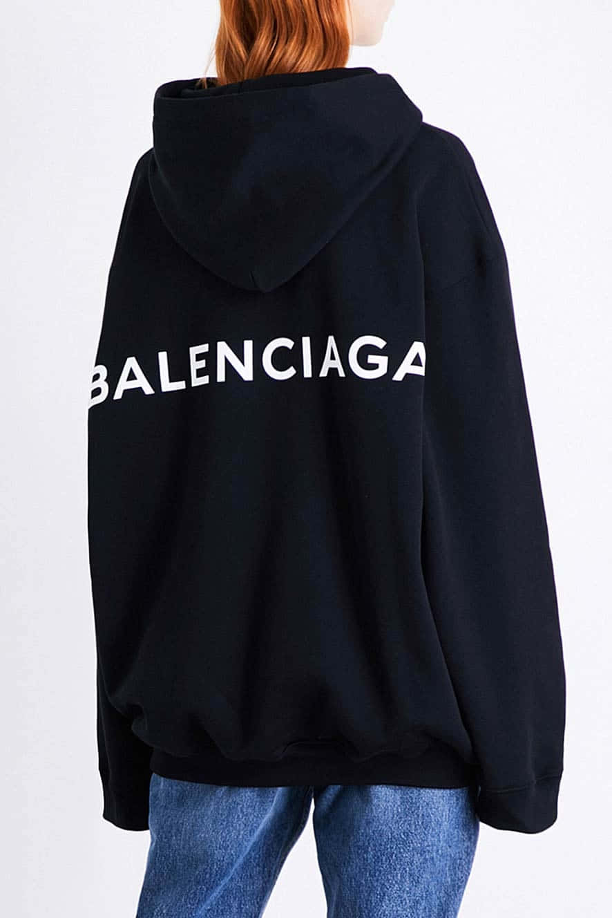 穿著黑色 Balenciaga 連帽衛衣和藍色牛仔褲的人，從後方觀看。