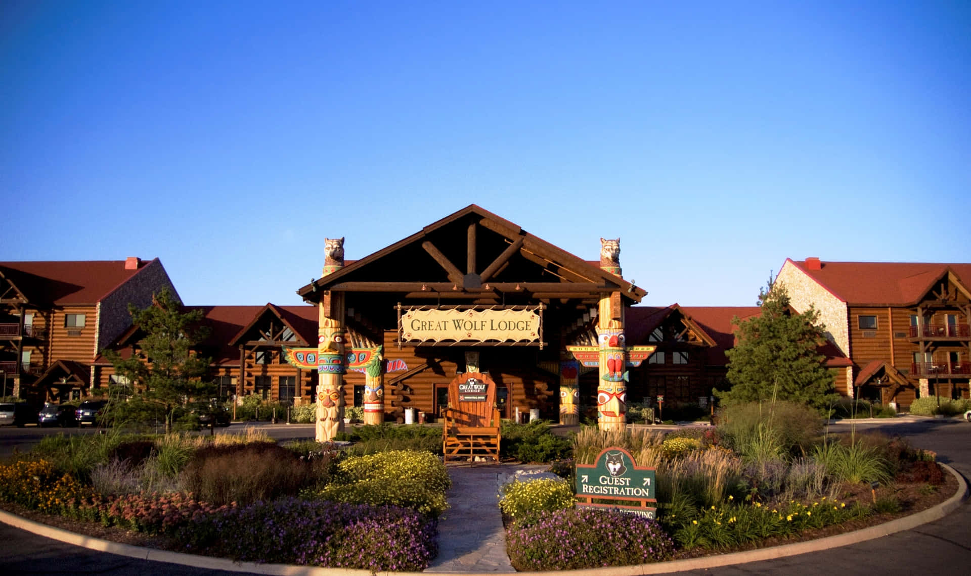 Great Wolf Lodge 入口，木結構建築和色彩繽紛的園景在日落時分。