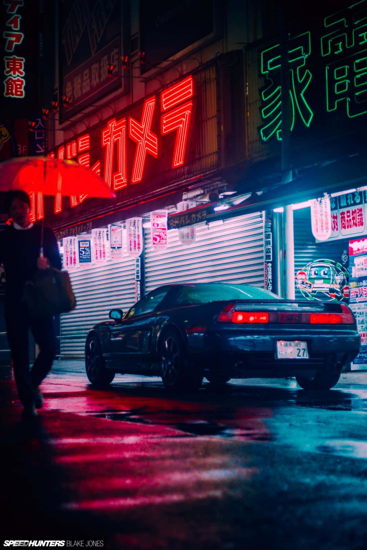 黑色跑車停在夜晚霓虹燈閃爍的東京雨街上，有人拿著紅色雨傘。