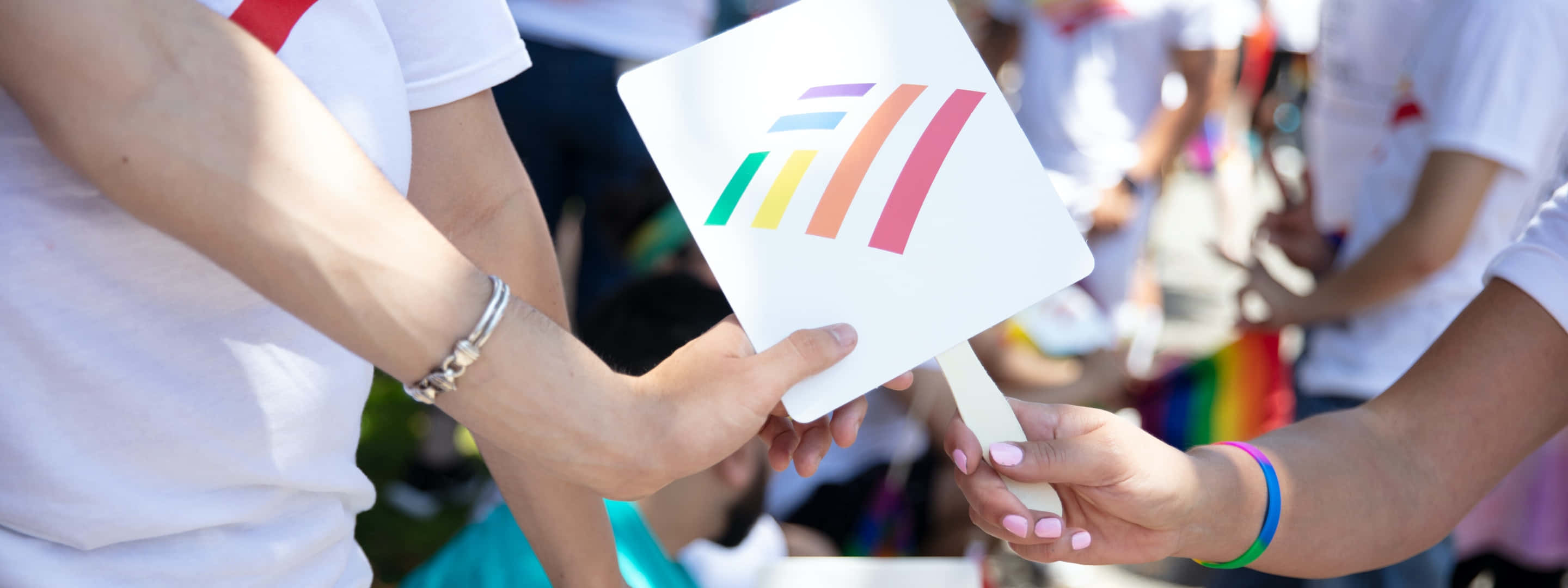 兩人在Pride慶祝活動中交換一把彩虹色的扇子。