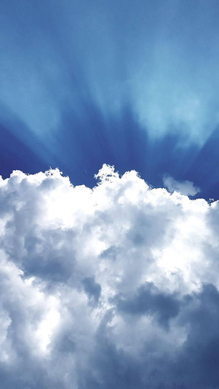 陽光穿過厚厚的白雲，照耀在鮮豔的藍天上。