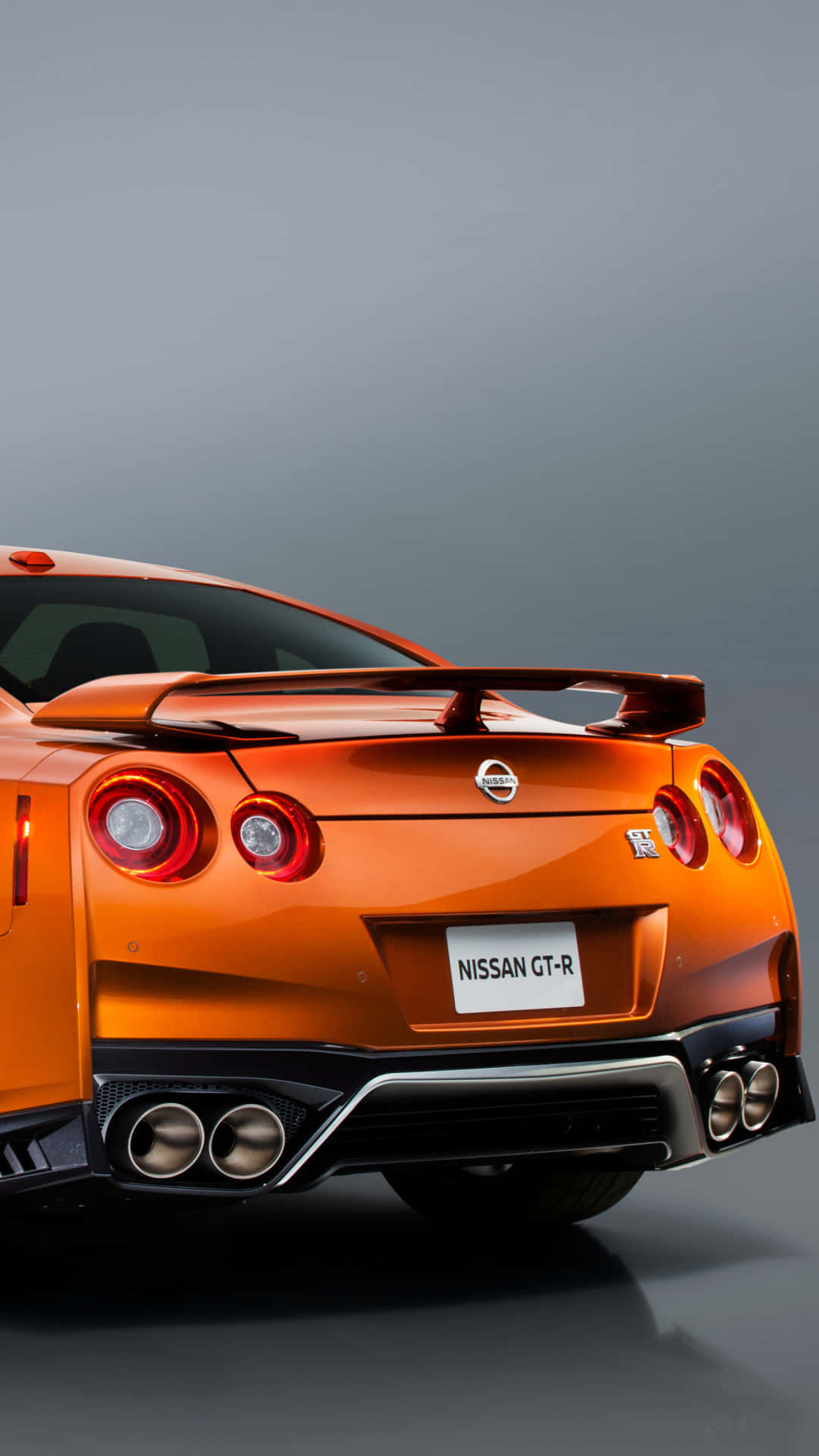 橙色日產GT-R跑車在工作室中的後視圖