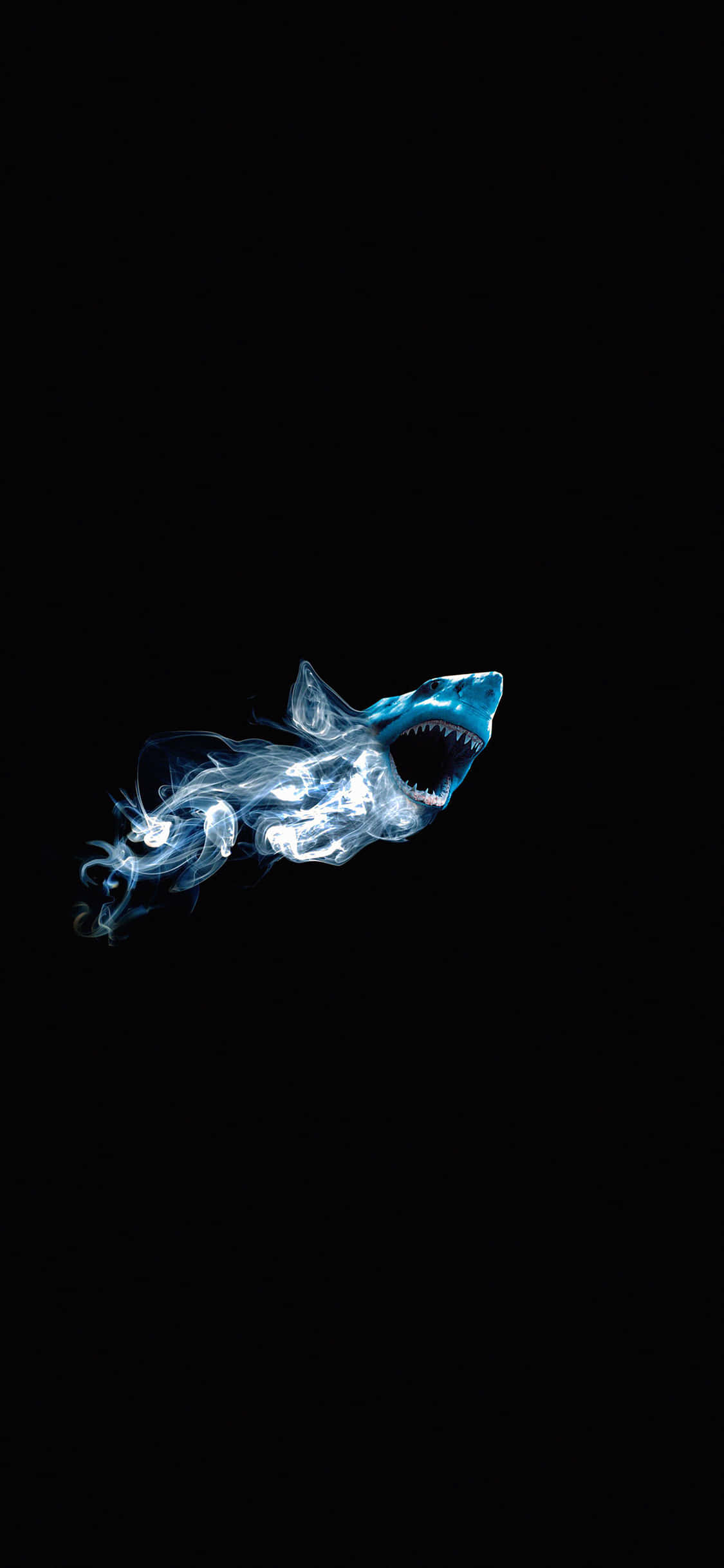 為科技愛好者設計 — Shark iPhone 壁紙 — 一條由煙霧組成的發光藍色鯊魚，張開嘴巴露出鋒利牙齒，劃破純粹的黑暗。