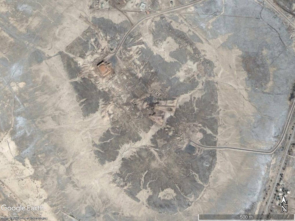 乾燥沙漠山谷的衛星圖像，包含道路和建築物。