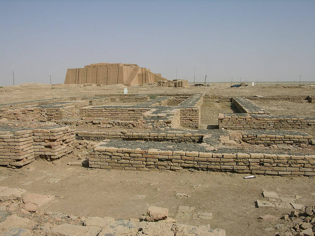 烈日下沙漠中的古代金字形神塔遺跡和磚地基。