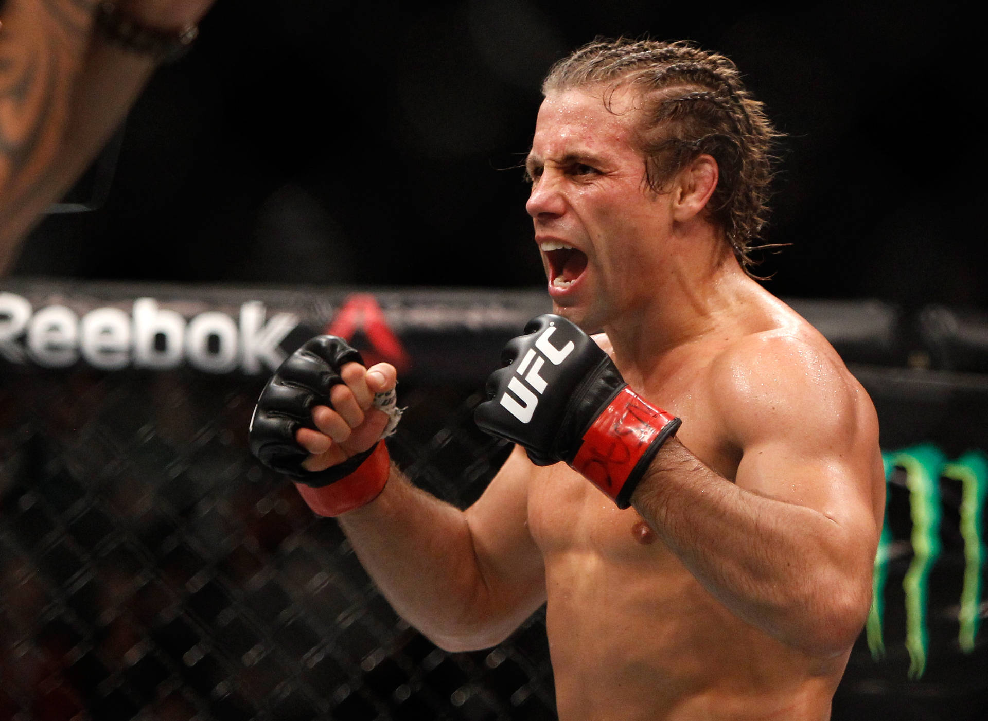 MMA拳手在八角籠中握緊拳頭慶祝勝利。
