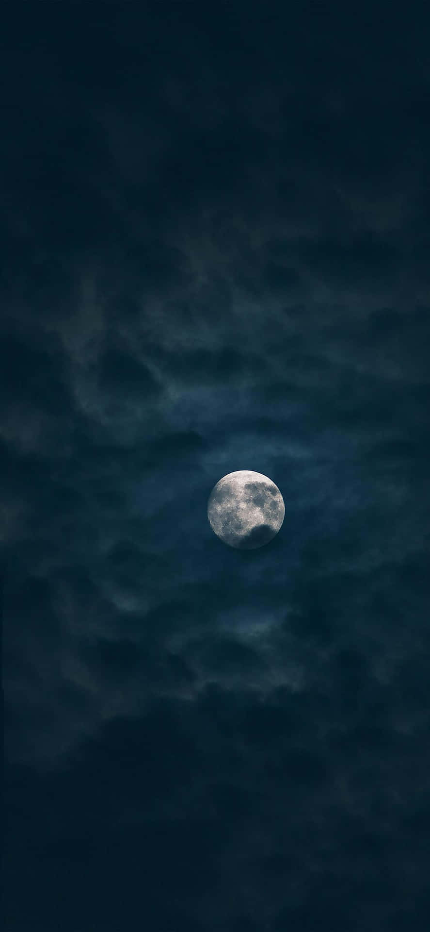 烏雲月色 iPhone 壁紙 — 一輪明亮的滿月穿過旋轉的烏雲，在陰沉的夜空中發光。
