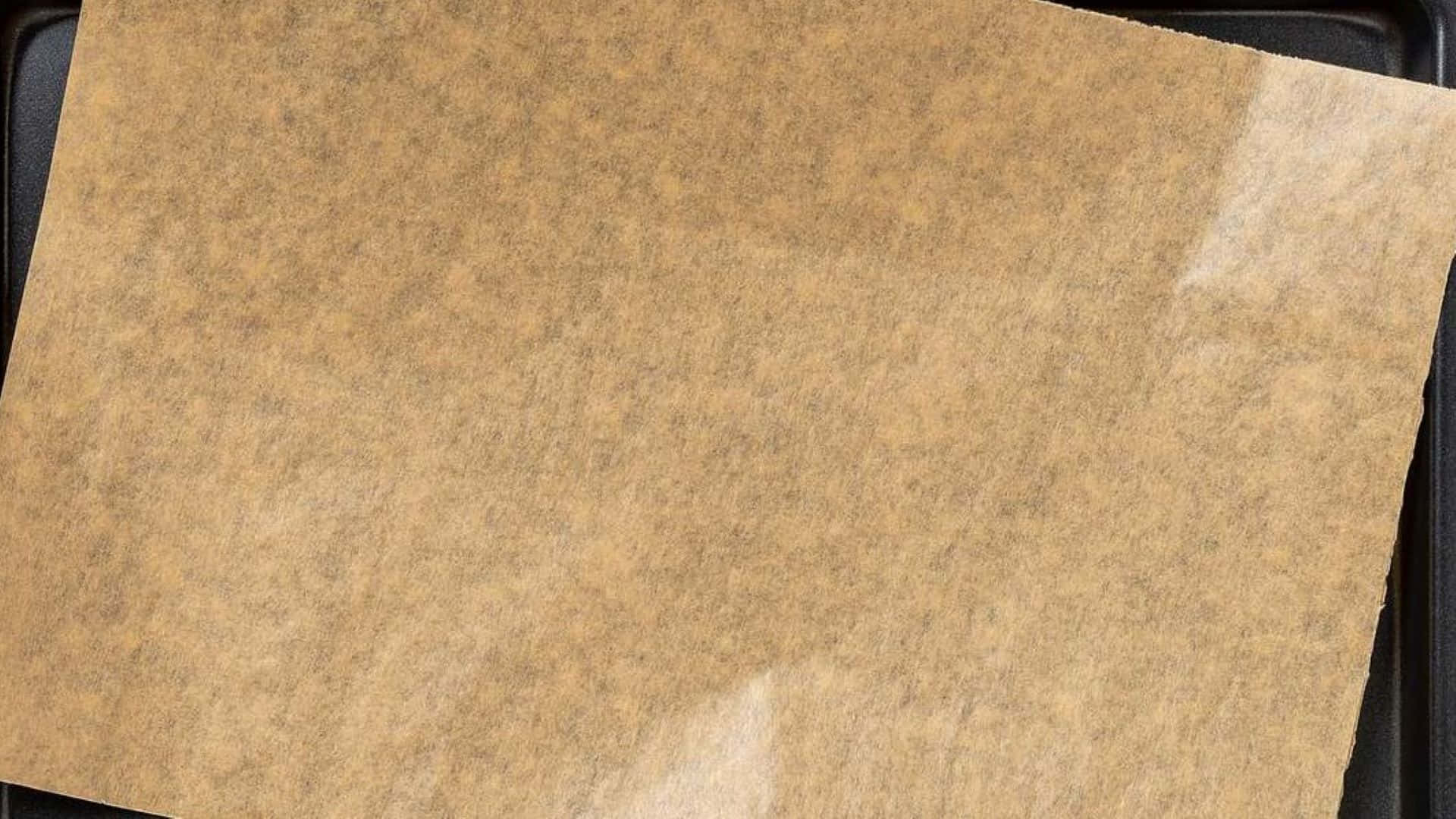 用於烹飪的深色烤盤上的棕色牛油紙。