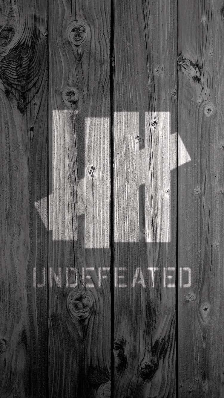 灰色木牆，上有粗體白色文字寫著 undefeated