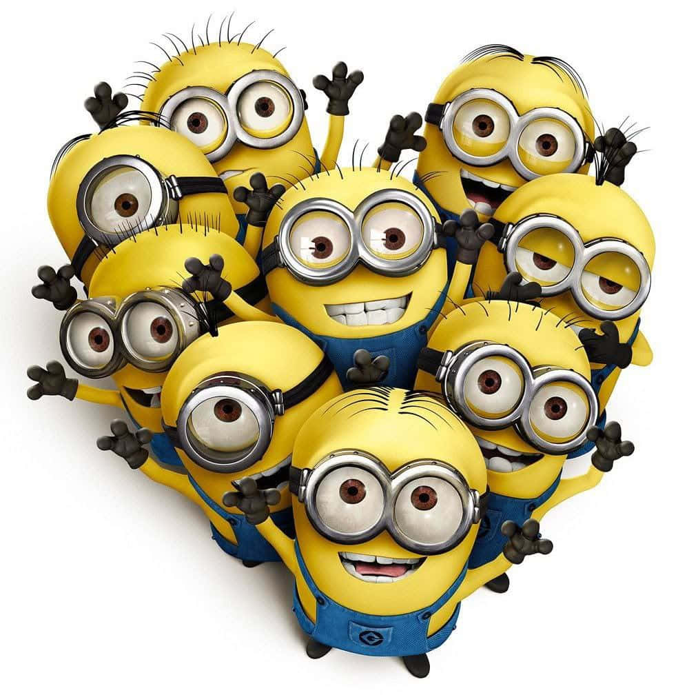一群穿著藍色工裝褲的黃色Minions揮手微笑。