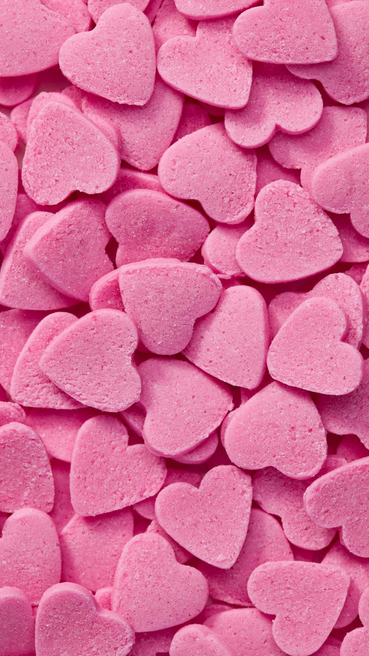 Heart Shape 桌布 壁紙 — 無數柔軟的粉紅色心形糖果堆疊在一起，形成紋理豐富、甜蜜浪漫的圖案特寫。