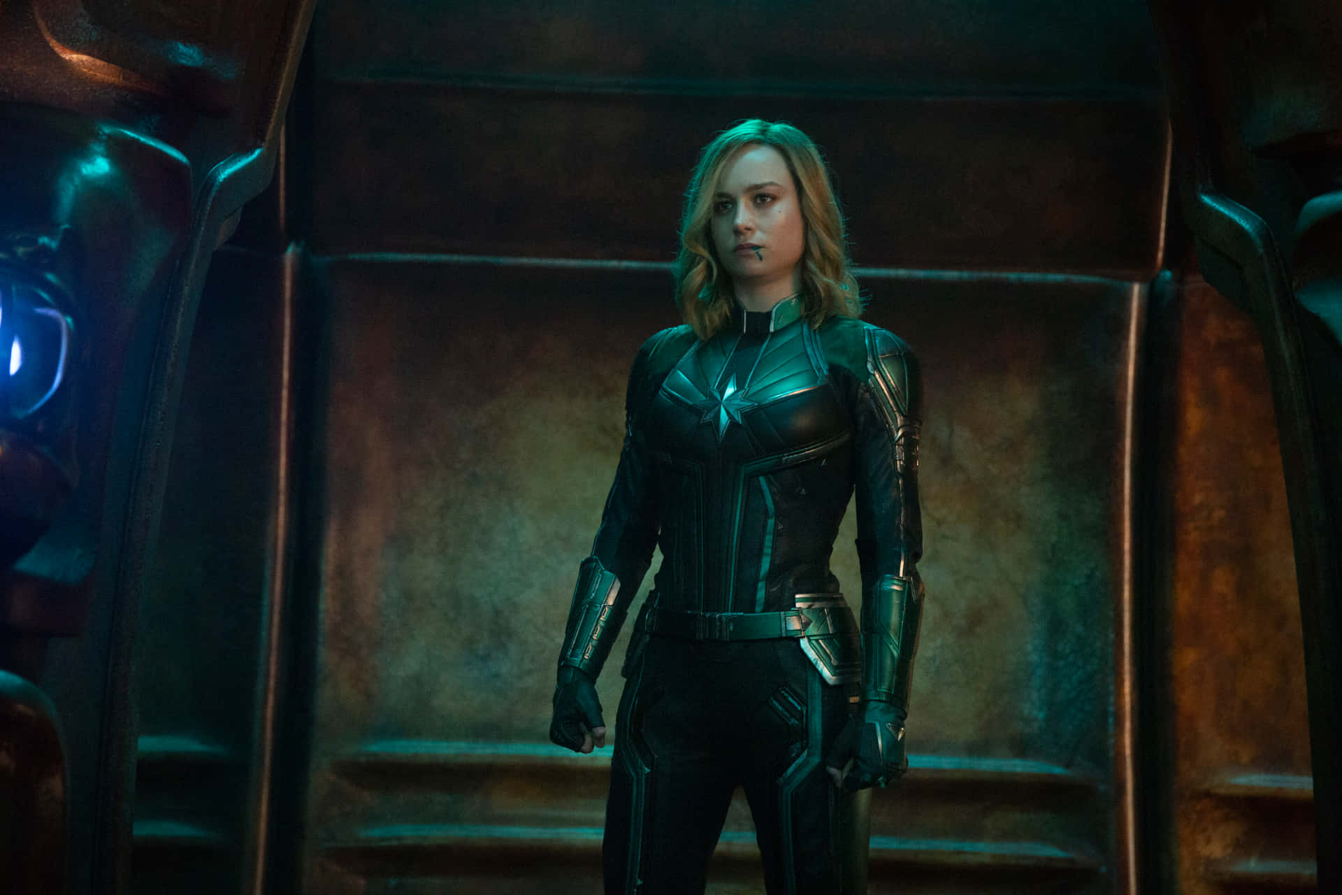Captain Marvel 著住佢嘅套裝企喺一個有發光藍燈嘅高科技房間。