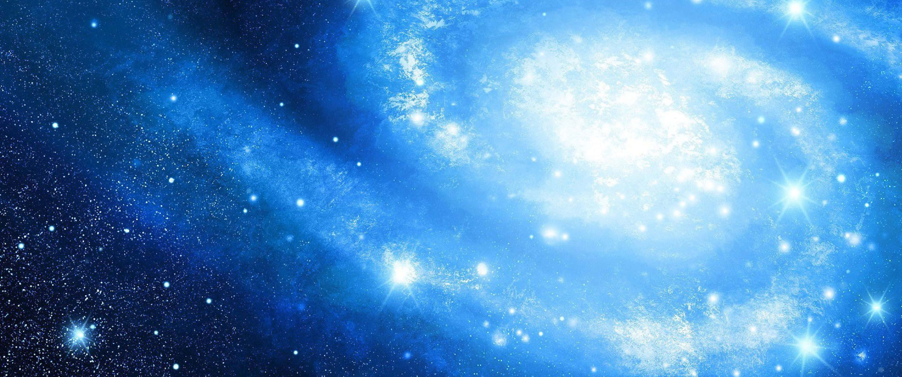 無盡的宇宙 壁紙 — 一個光芒四射的藍色螺旋星系，在深邃的太空背景下，旋轉著發光的恆星和宇宙塵埃。