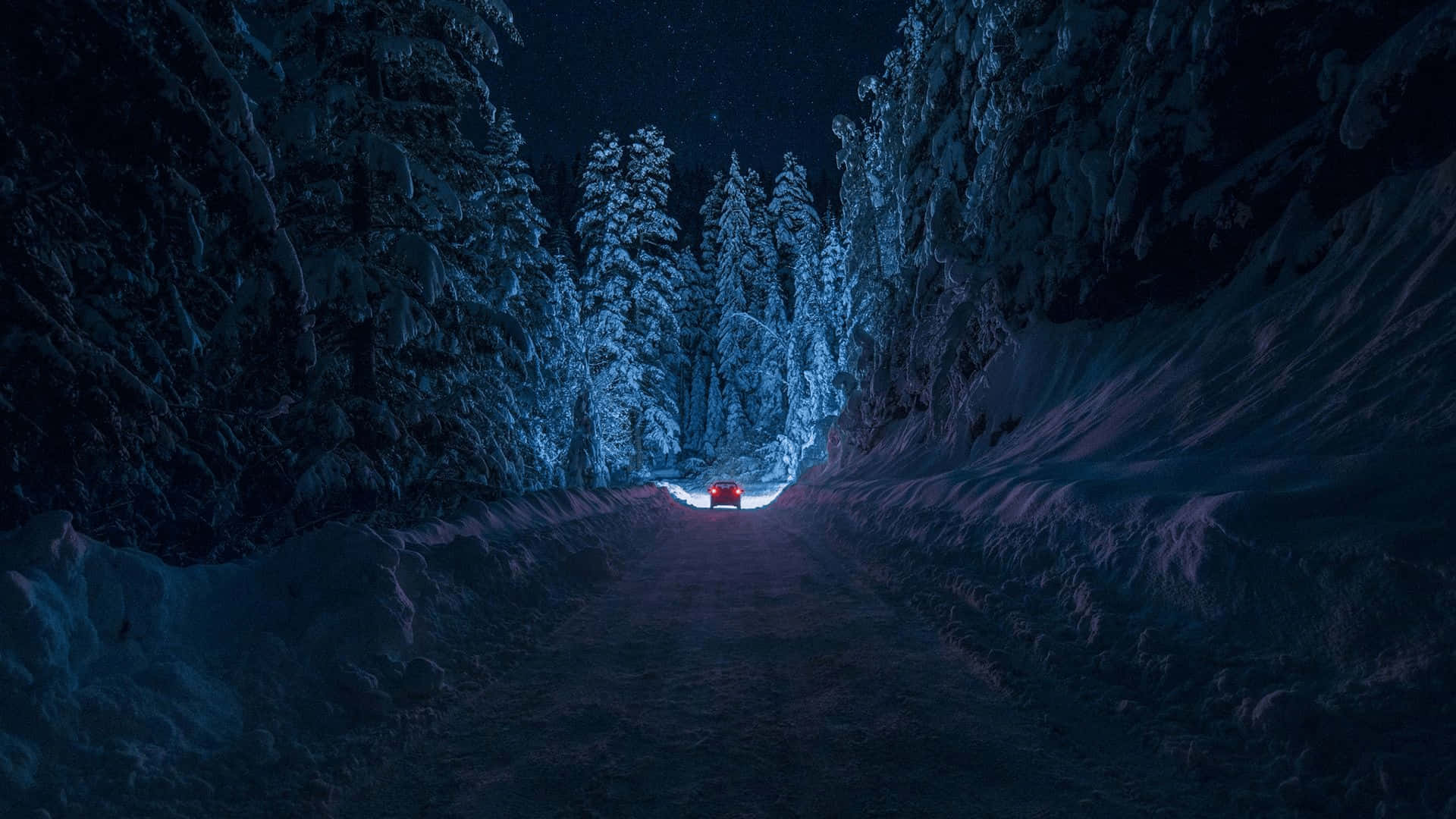 無盡的淡藍色漸層 壁紙 — 一輛孤獨的紅色汽車在星空下的雪地森林道路上行駛。
