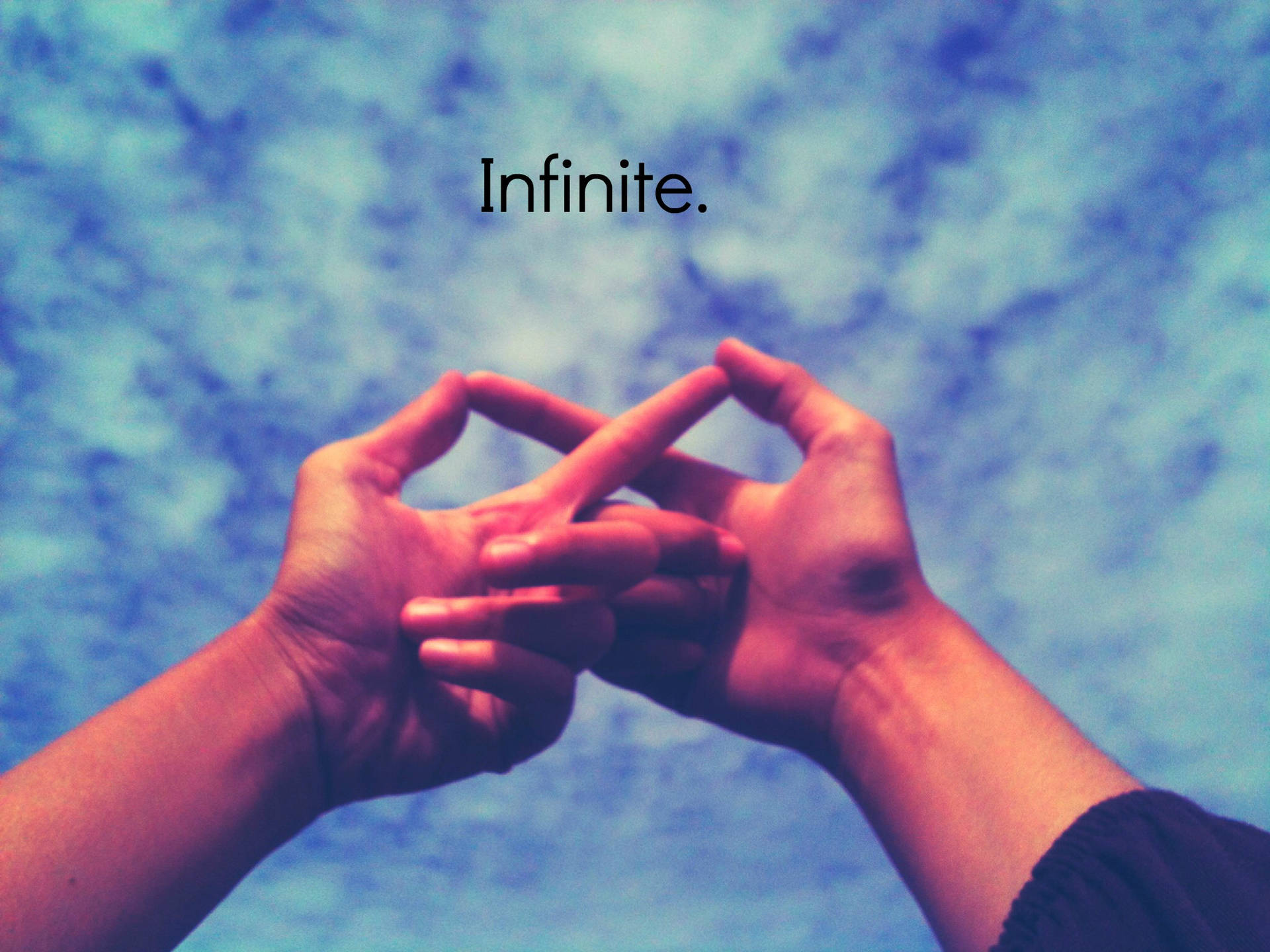 兩隻手在藍天下形成一個無限標誌，並帶有「infinite」一詞。