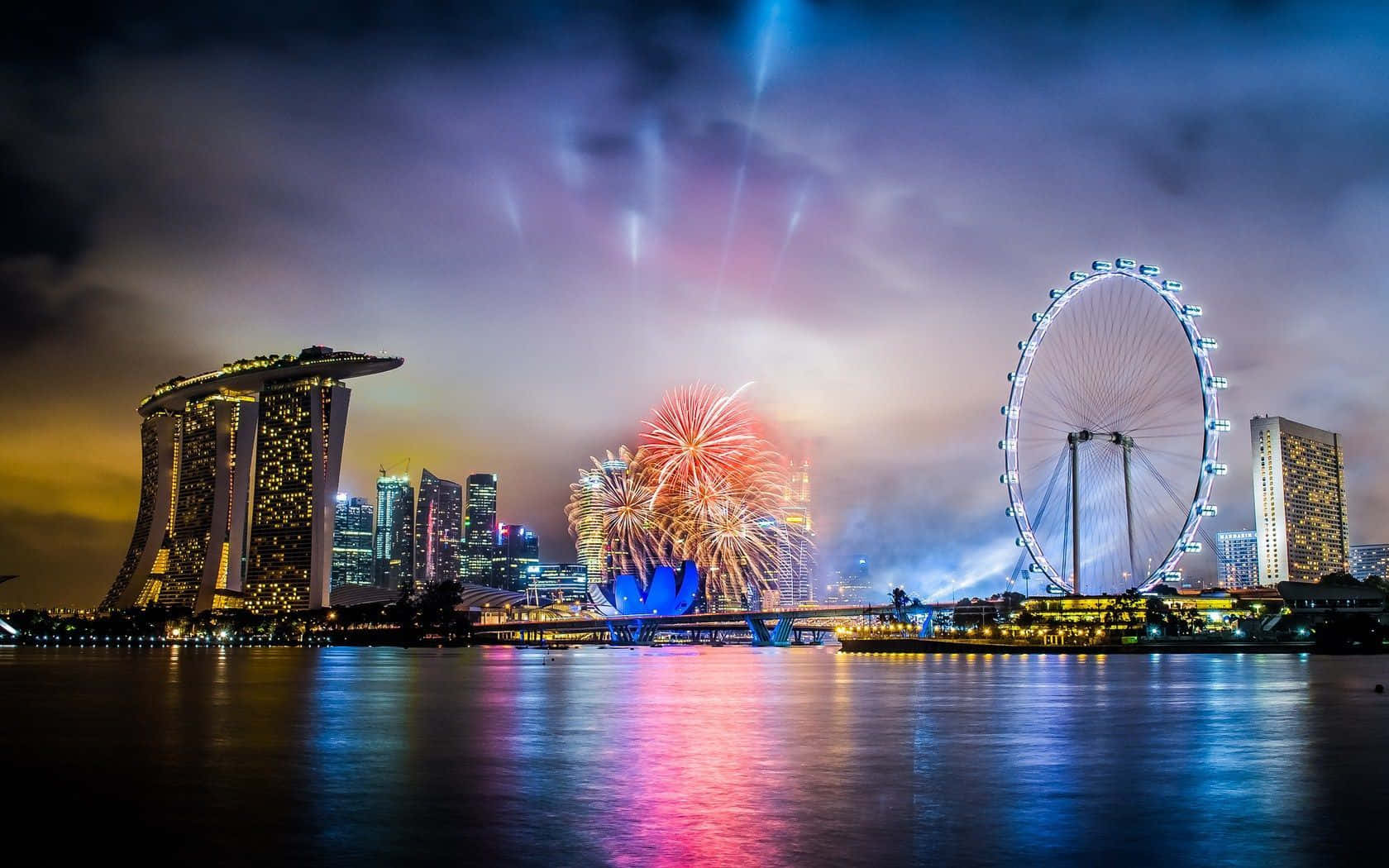 Dubai 桌布 壁紙 — 煙花在新加坡天際線上綻放，濱海灣金沙和新加坡摩天觀景輪在夜晚被點亮。