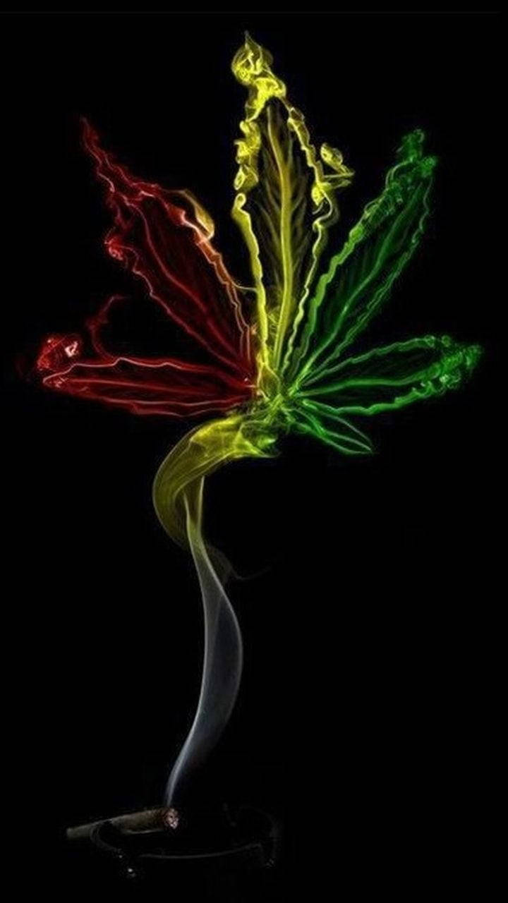 發光的紅、黃、綠色大麻葉從燃燒的大麻煙中升起，背景為黑色