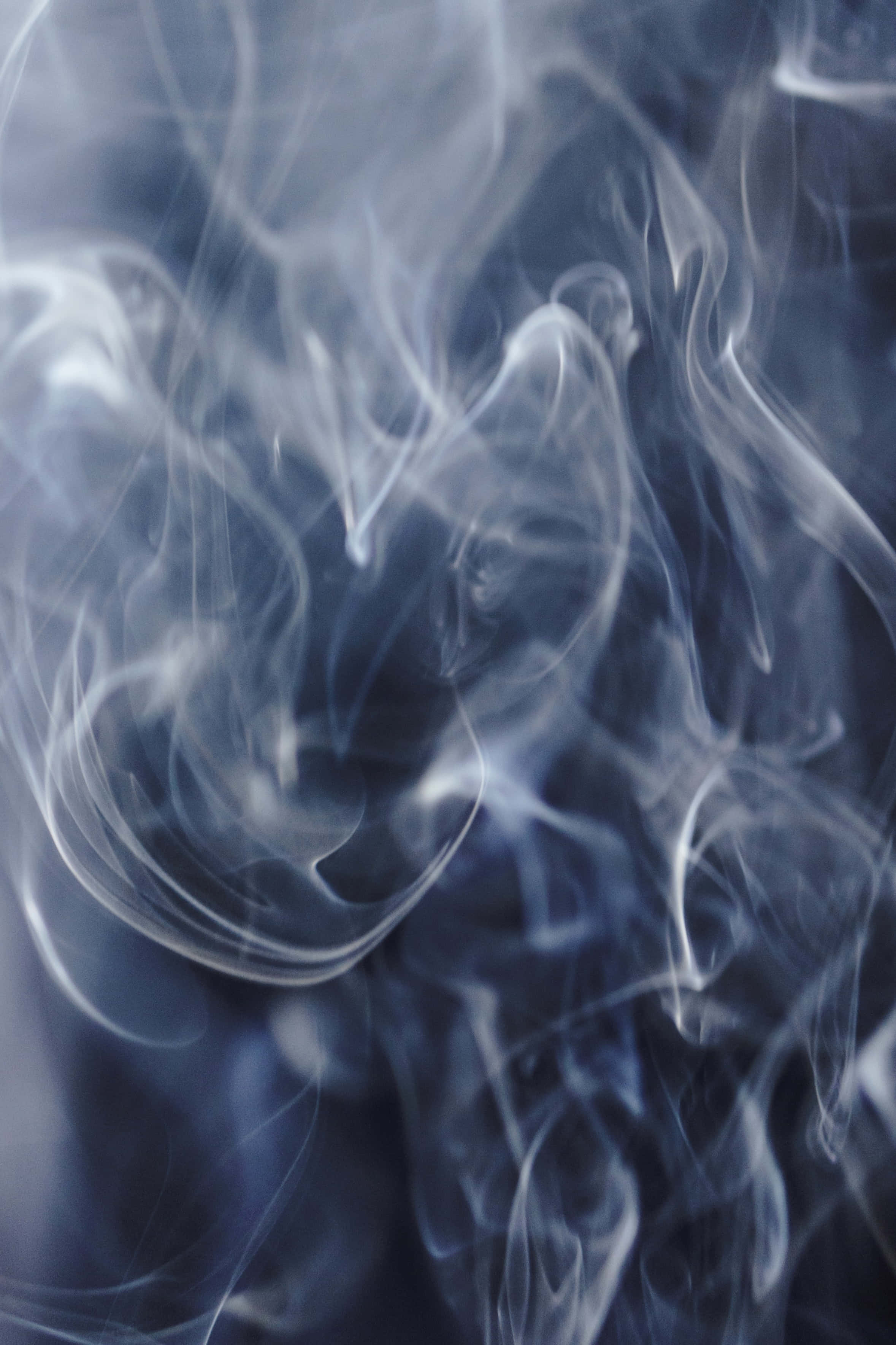煙霧背景：抽象煙霧圖案 壁紙 — 清涼藍煙的縹緲縷縷在黑暗背景下旋轉扭動，上演一場迷人的抽象舞蹈。