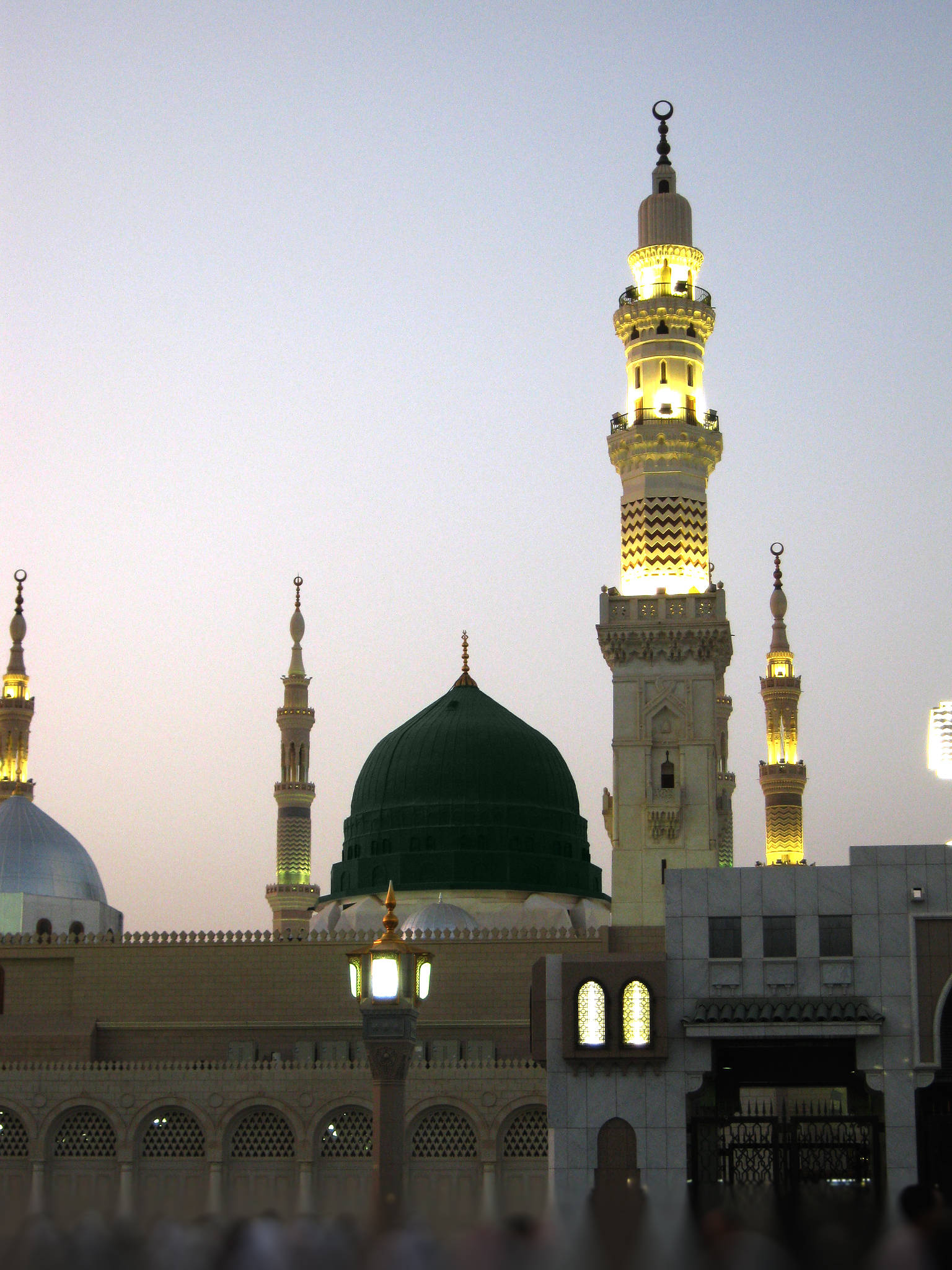 Madina Sharif 桌布 壁紙 — 照亮嘅清真寺宣禮塔同綠色圓頂喺柔和嘅暮色天空下溫暖咁發光。