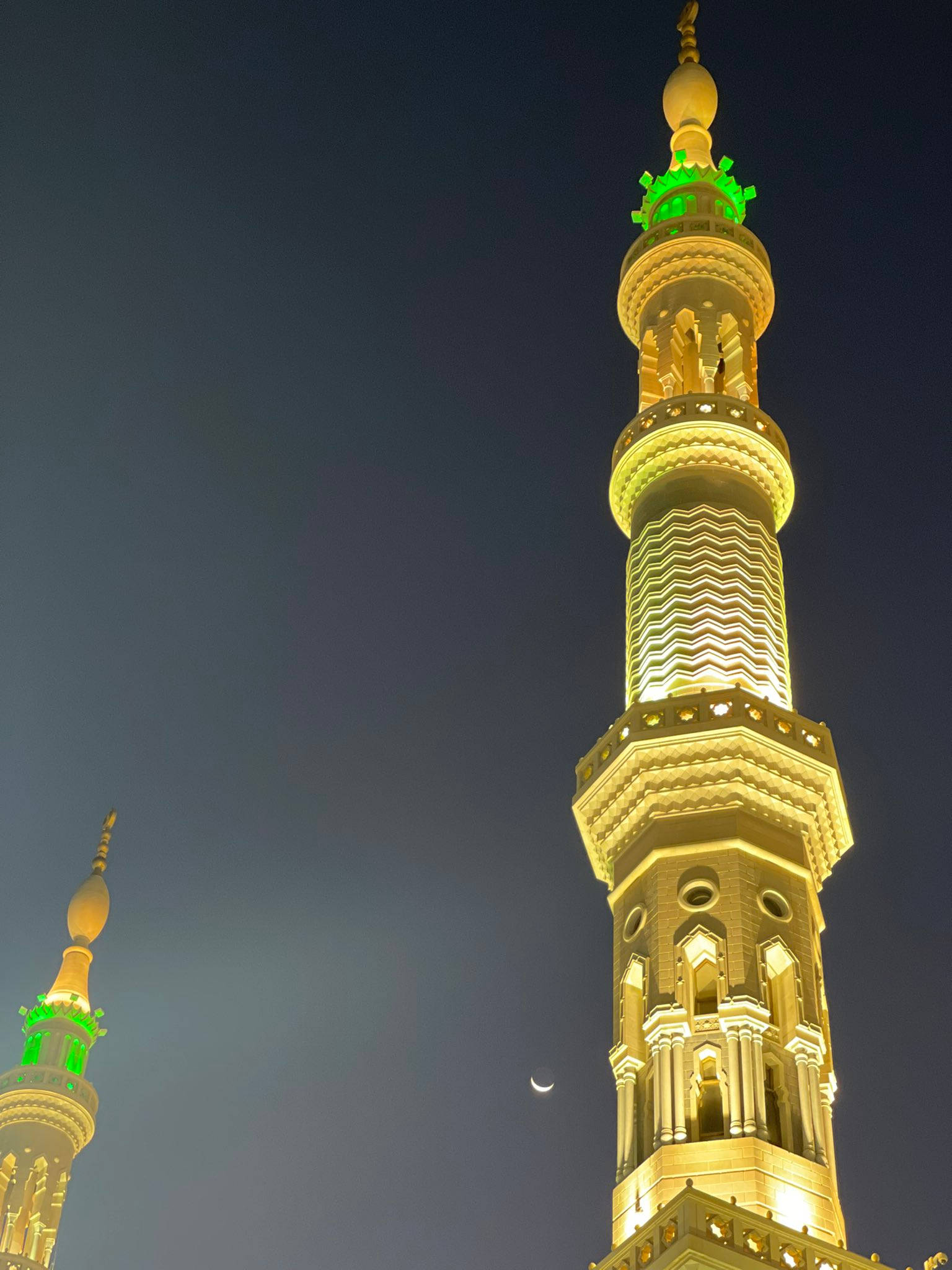 Madina Sharif 桌布 壁紙 — 照亮嘅清真寺宣禮塔喺深藍夜空下發出金色光芒，新月清晰可見。