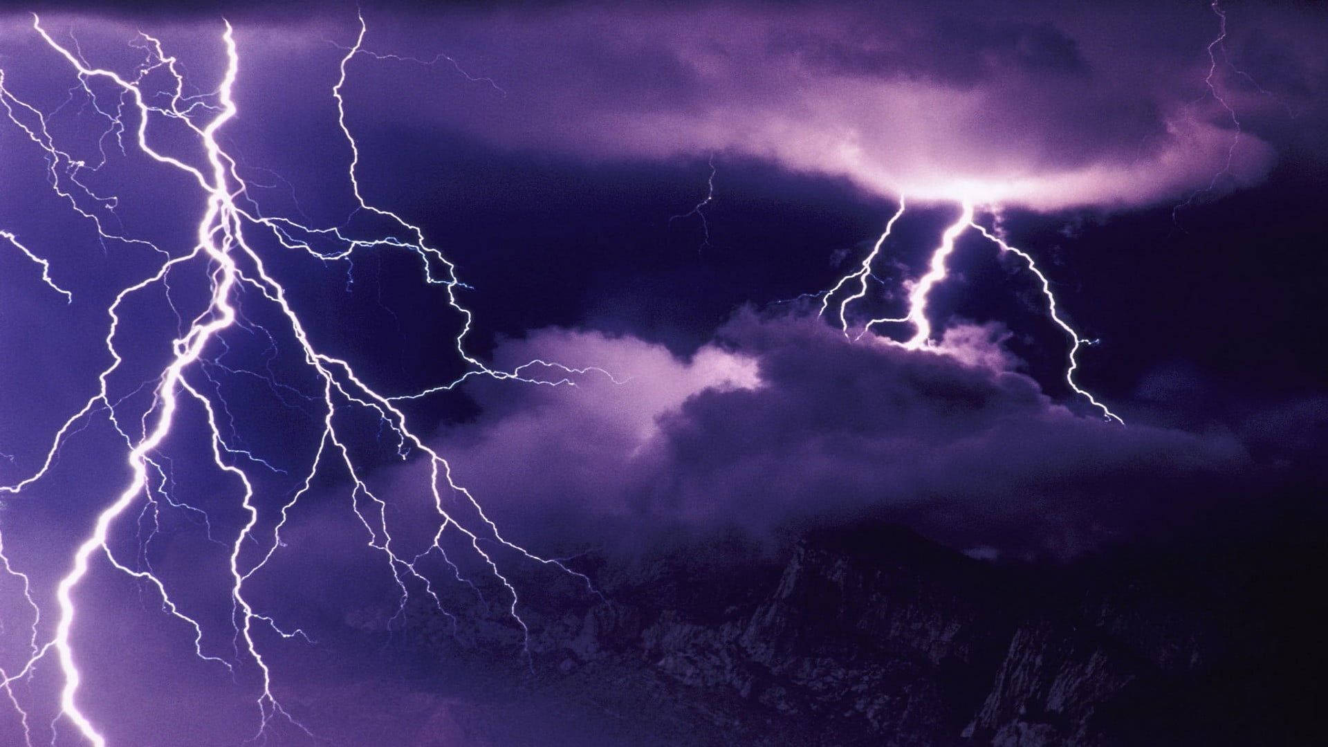 暴風雨中，紫色閃電擊中黑暗的山脈。