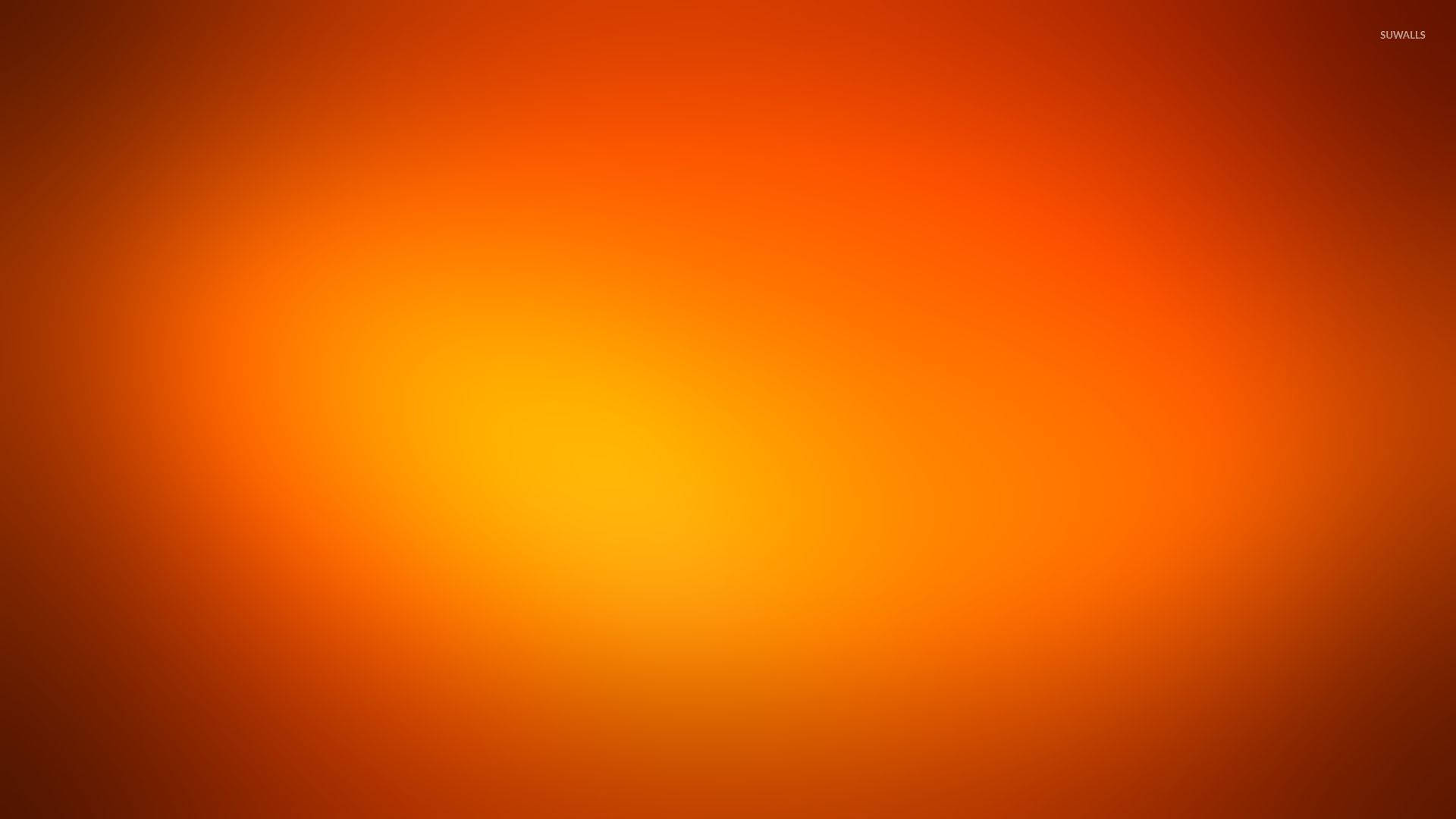 熱橙漸層 壁紙 — 暖橙色和黃色的平滑漸變從明亮的中心向外輻射，邊緣逐漸褪成深橙色。